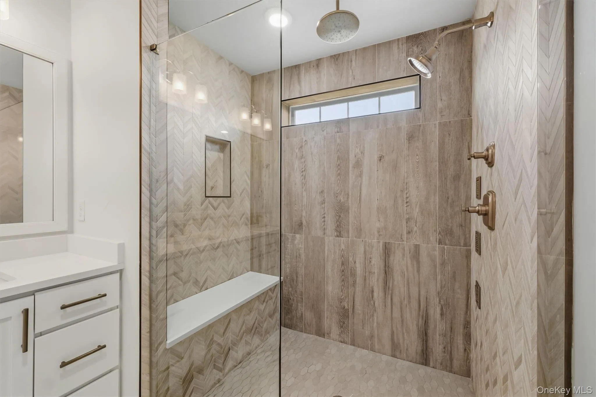 Master bathroom. Walk-in shower with a glass enclosure, dual shower heads, and an integrated bench. Dual vanity. Master bathroom. Walk-in shower with a glass enclosure, dual shower heads, and an integrated bench. Dual vanity.