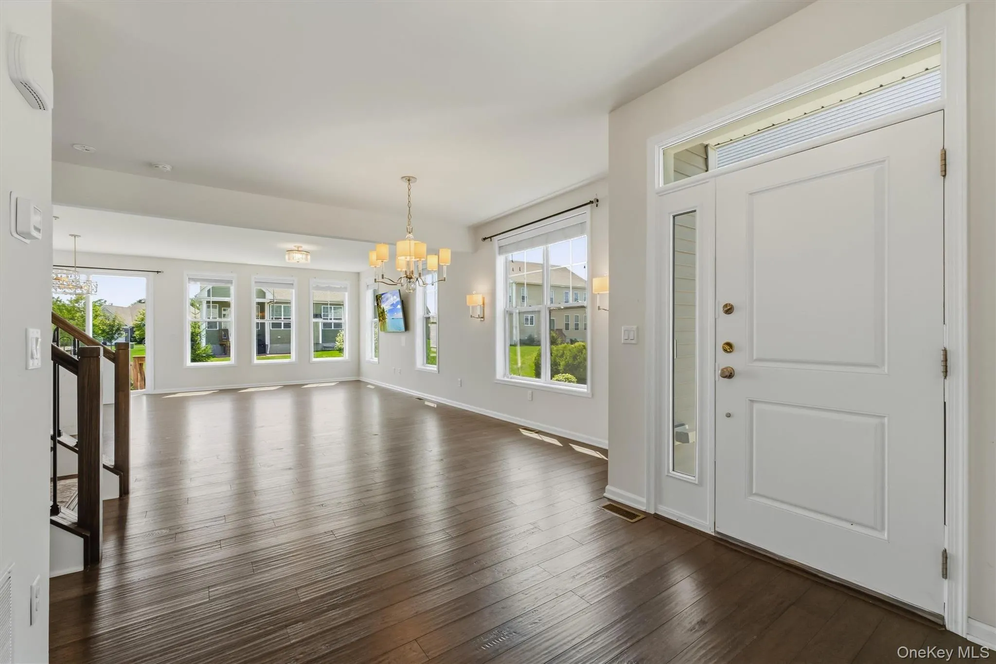 Entryway with a solid white door, an adjacent sidelight, and an overhead transom window Entryway with a solid white door, an adjacent sidelight, and an overhead transom window