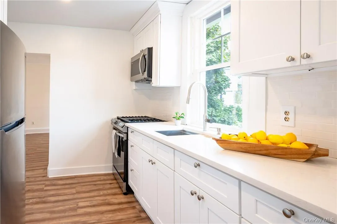 Kitchen featuring stainless steel appliances, sink and white cabinets Kitchen featuring stainless steel appliances, sink and white cabinets