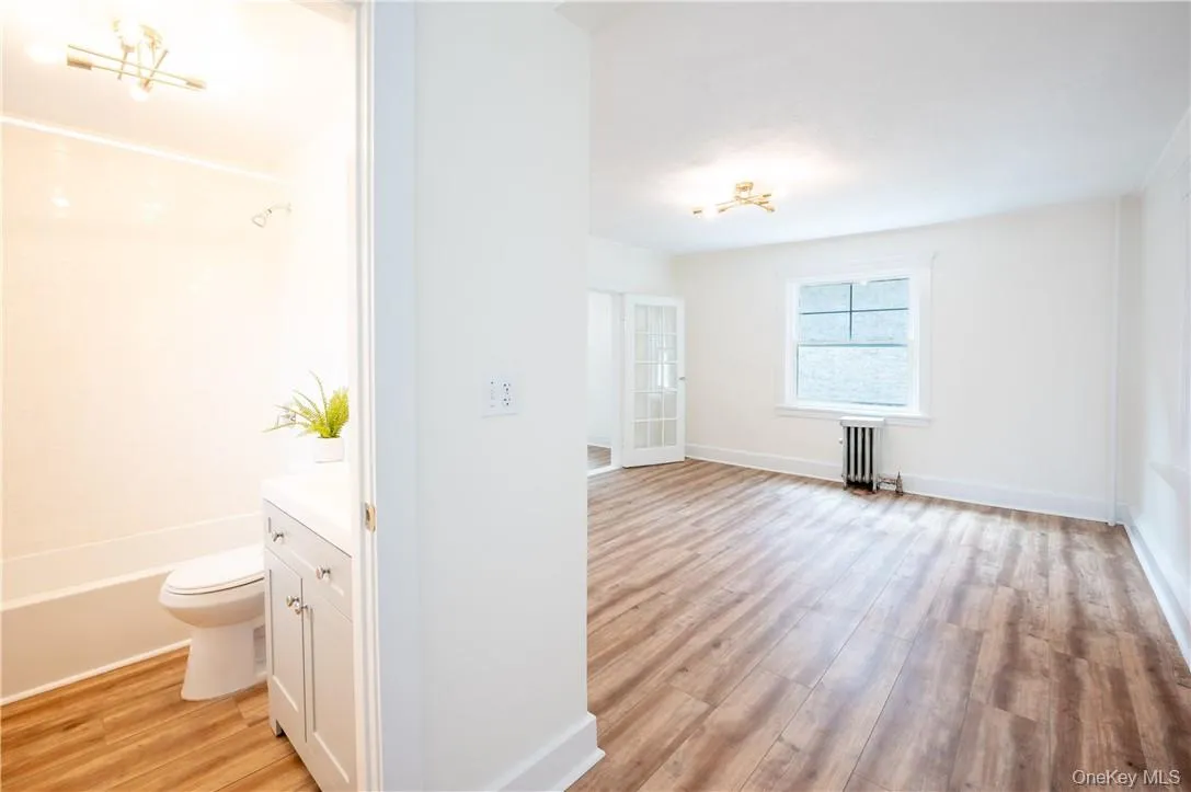 Shared view of full bathroom and living room on second floor. Shared view of full bathroom and living room on second floor.
