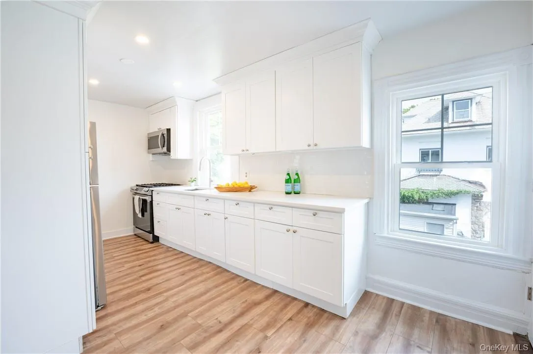 Kitchen with white cabinets, stainless steel appliances, and a healthy amount of sunlight Kitchen with white cabinets, stainless steel appliances, and a healthy amount of sunlight