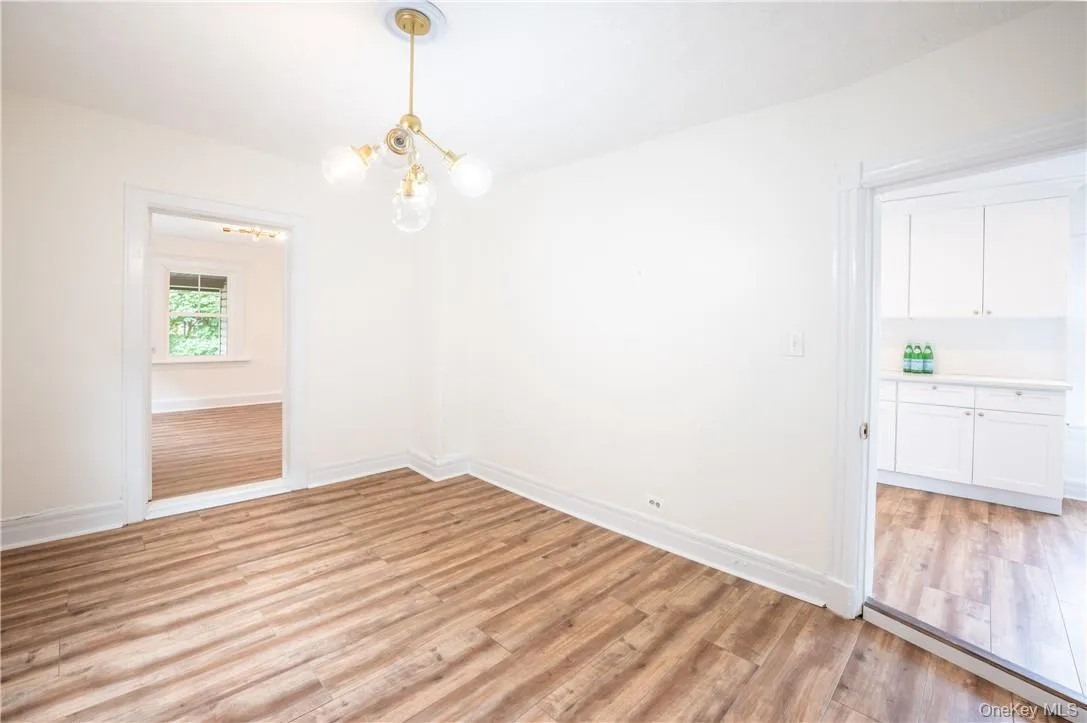 Unfurnished dining area featuring an inviting chandelier could also be used as another bedroom as it also has a closet not seen in this photo. Unfurnished dining area featuring an inviting chandelier could also be used as another bedroom as it also has a closet not seen in this photo.
