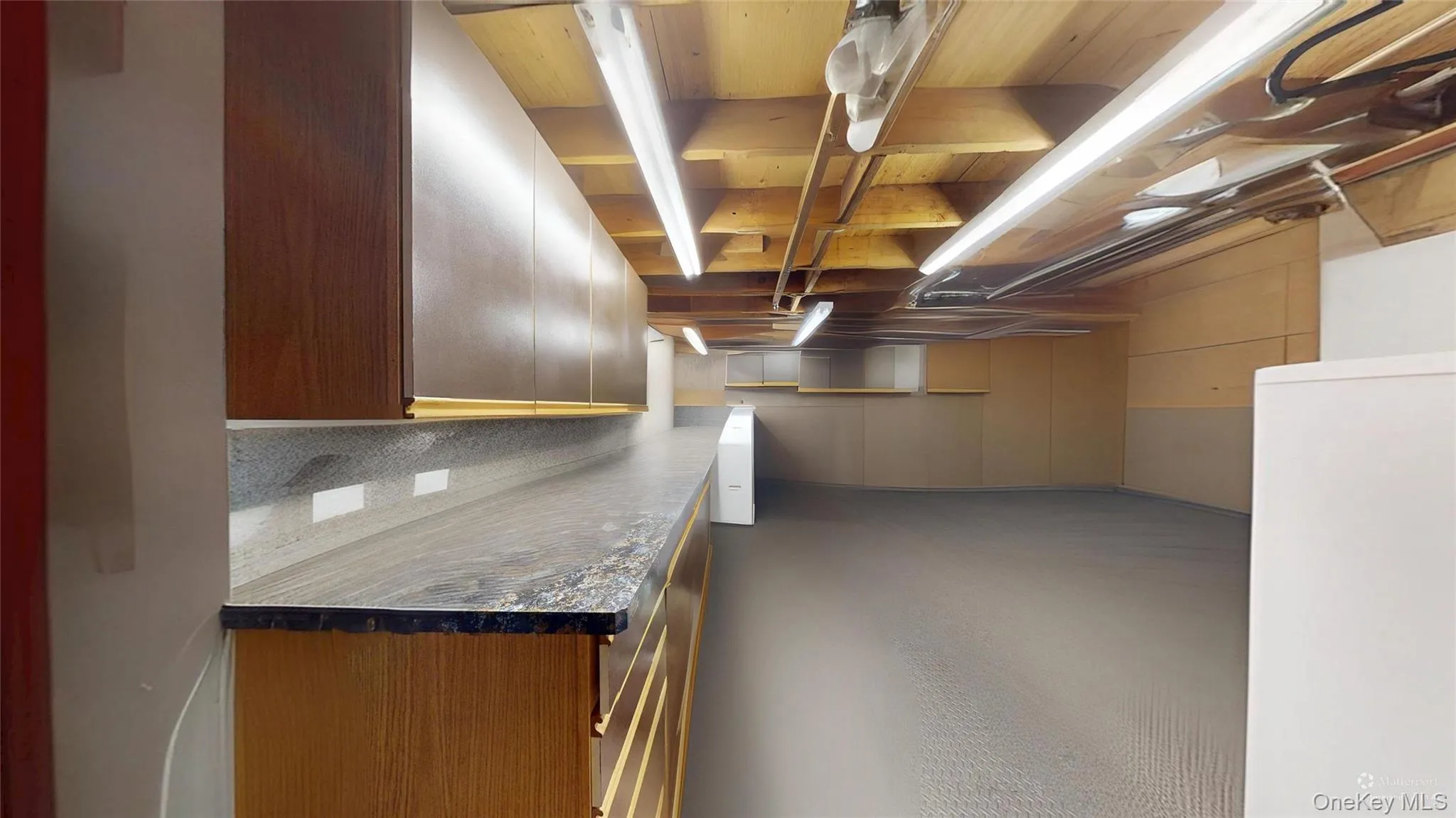 (DE furnished photo) shows a well-lit basement area with a workbench and more! (DE furnished photo) shows a well-lit basement area with a workbench and more!