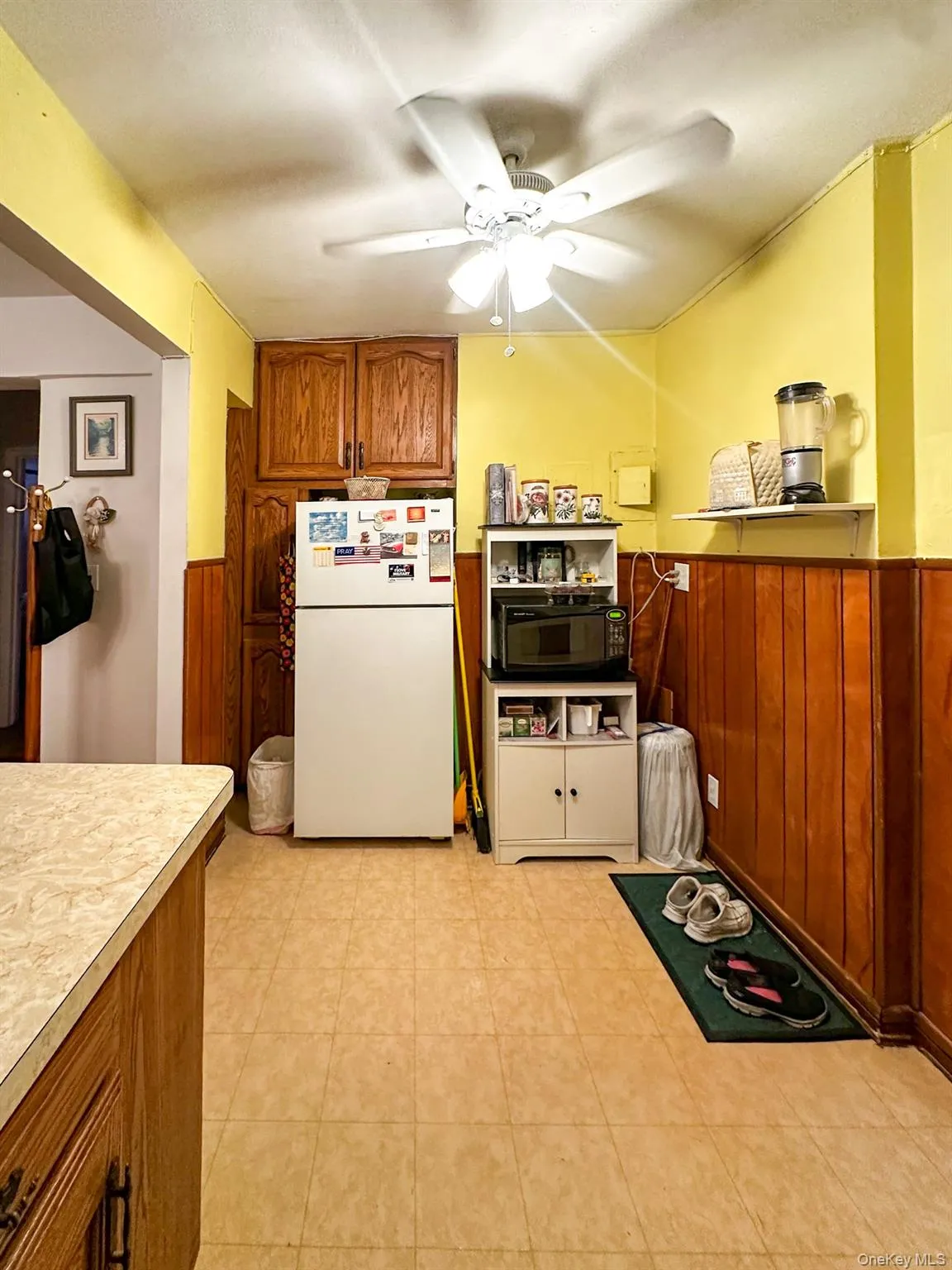 Kitchen area featuring wood-finish lower cabinetry with a light-colored countertop Kitchen area featuring wood-finish lower cabinetry with a light-colored countertop