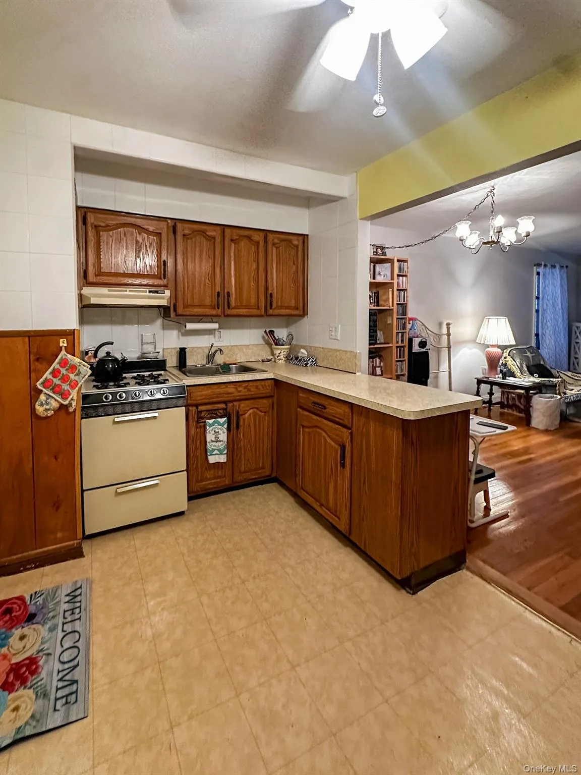 Kitchen featuring honey-toned wood cabinetry, gas range, a light-colored countertop. Kitchen featuring honey-toned wood cabinetry, gas range, a light-colored countertop.