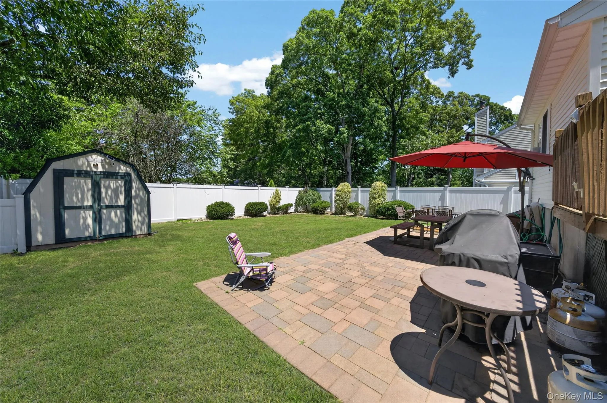 Expansive backyard featuring a paver patio, a freestanding storage shed, and a privacy fence Expansive backyard featuring a paver patio, a freestanding storage shed, and a privacy fence