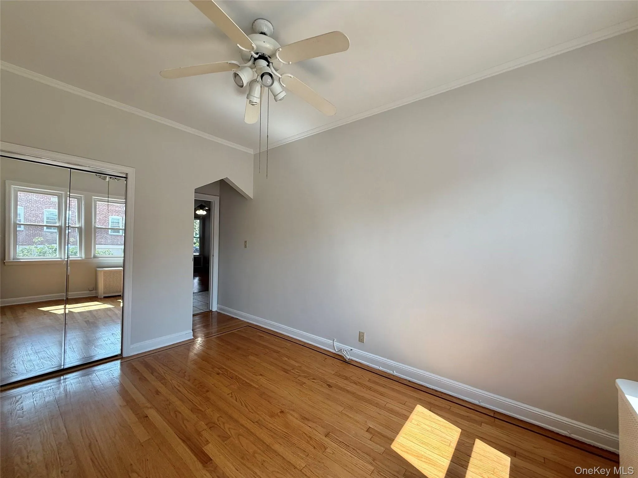 Second bedroom with elegant hardwood flooring, a ceiling fan with light fixture, 2 windows, large closet Second bedroom with elegant hardwood flooring, a ceiling fan with light fixture, 2 windows, large closet