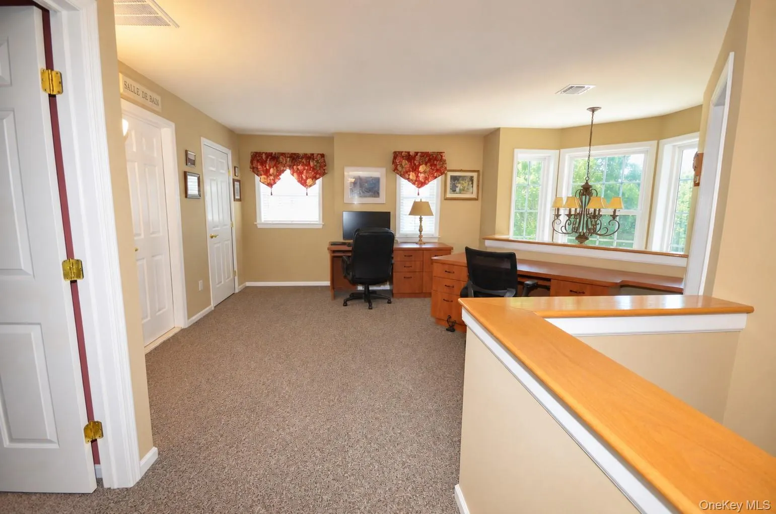Spacious bonus room featuring carpet flooring, two paneled doors, and a bay window area Spacious bonus room featuring carpet flooring, two paneled doors, and a bay window area