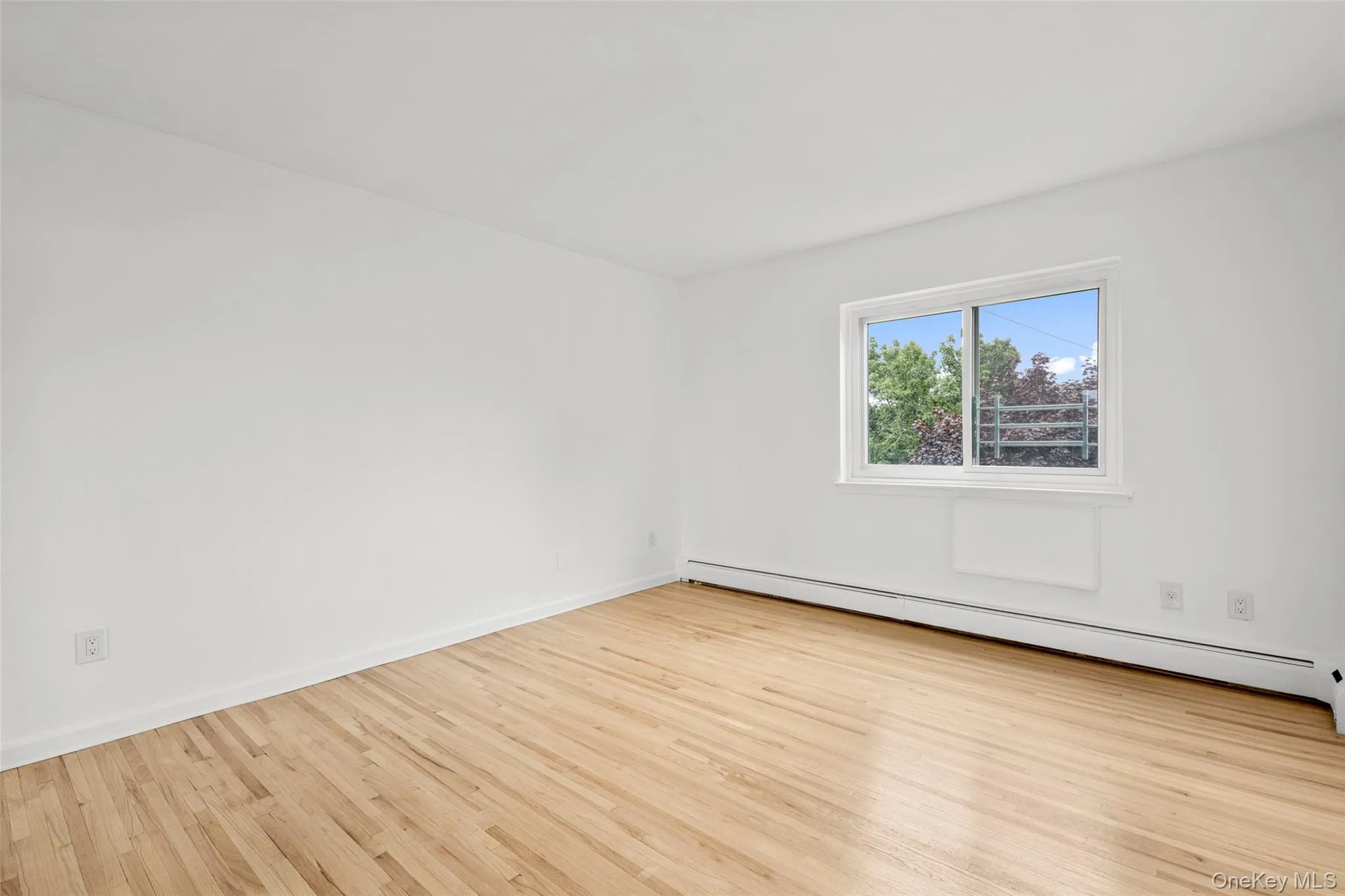Primary bedroom with large windows, freshly painted walls, hardwood floors and mirrored double closet doors. Primary bedroom with large windows, freshly painted walls, hardwood floors and mirrored double closet doors.