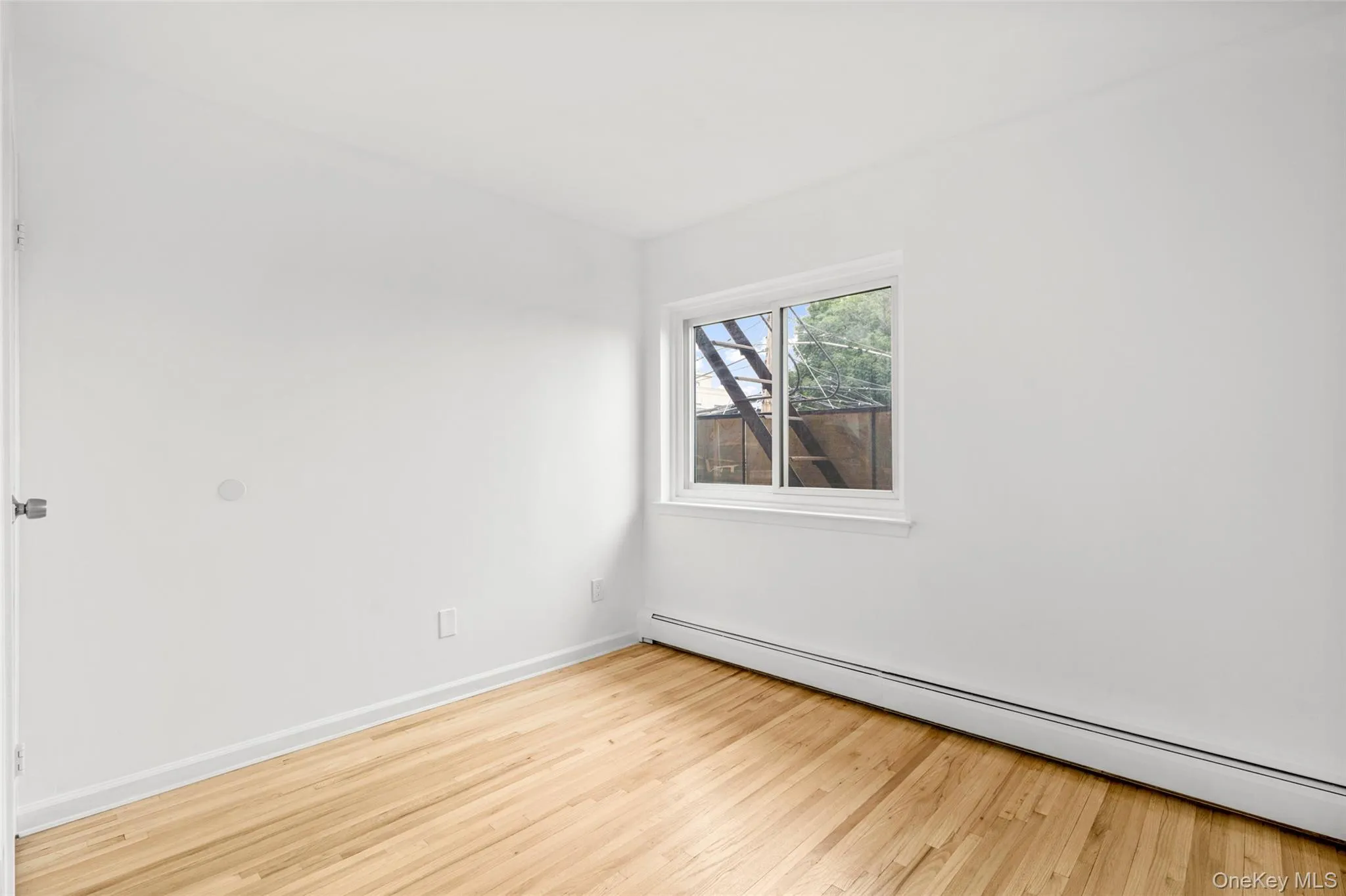Second bedroom is freshly painted with hardwood floors and baseboard heating. Second bedroom is freshly painted with hardwood floors and baseboard heating.