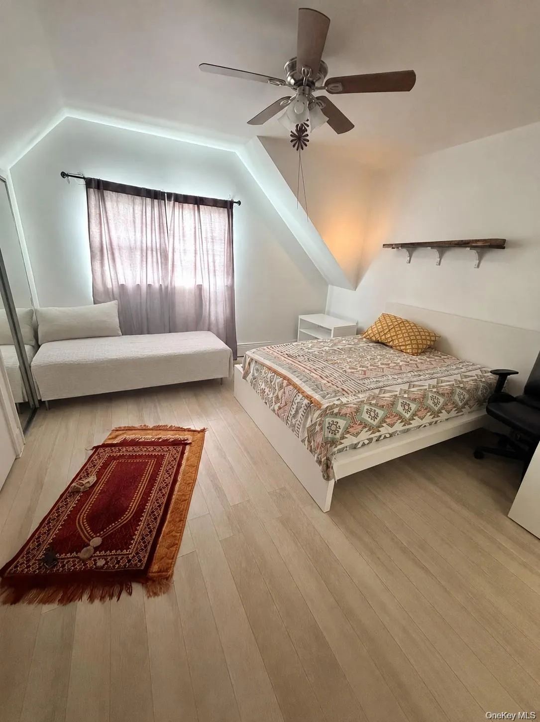 Light-toned wood-finish flooring complements the white walls and sloped ceiling Light-toned wood-finish flooring complements the white walls and sloped ceiling