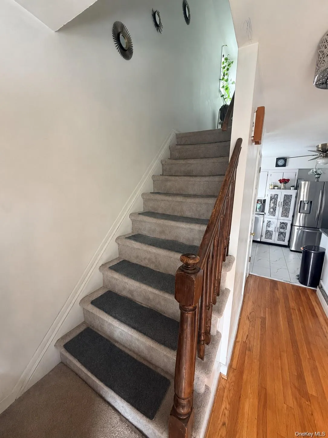 Carpeted staircase with a wood banister and balusters Carpeted staircase with a wood banister and balusters