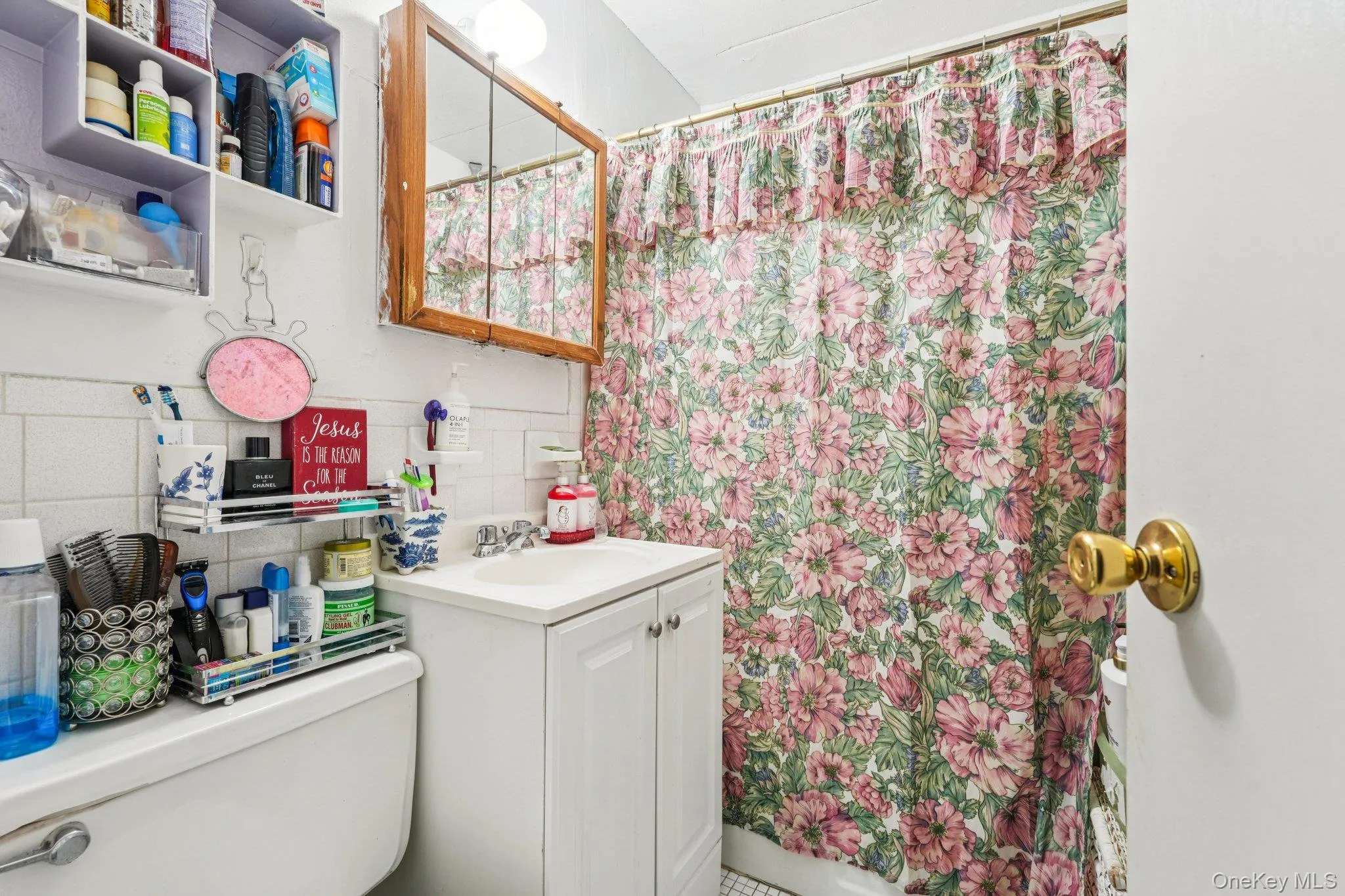 Full bath featuring vanity, a shower with shower curtain, decorative backsplash, and tile walls Full bath featuring vanity, a shower with shower curtain, decorative backsplash, and tile walls
