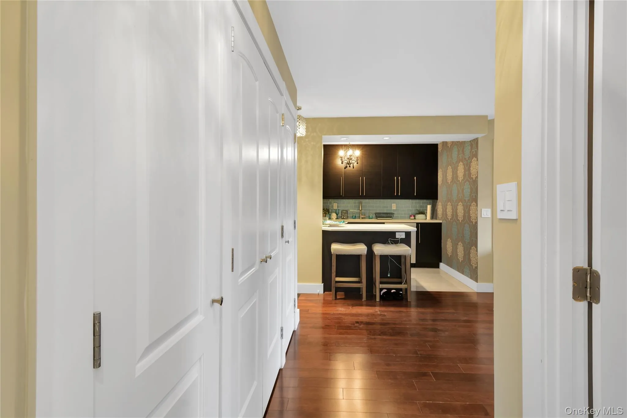 Hall with dark wood-type flooring and baseboards Hall with dark wood-type flooring and baseboards