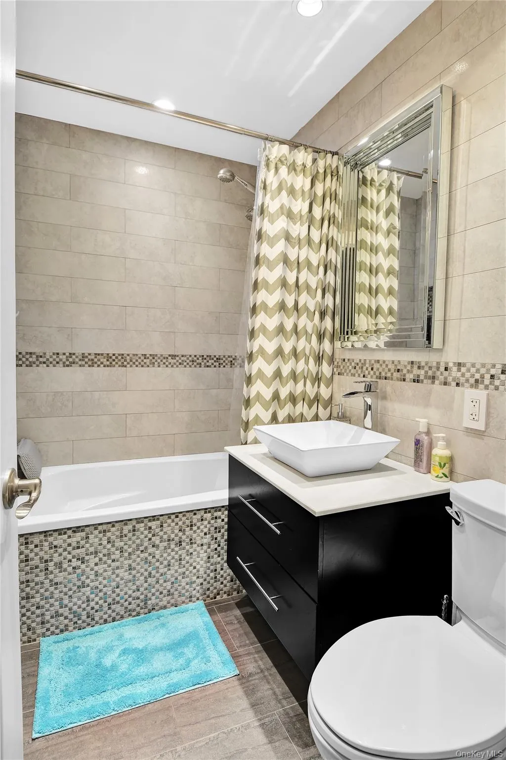Bathroom featuring tile walls, tiled shower / bath, vanity, and recessed lighting Bathroom featuring tile walls, tiled shower / bath, vanity, and recessed lighting