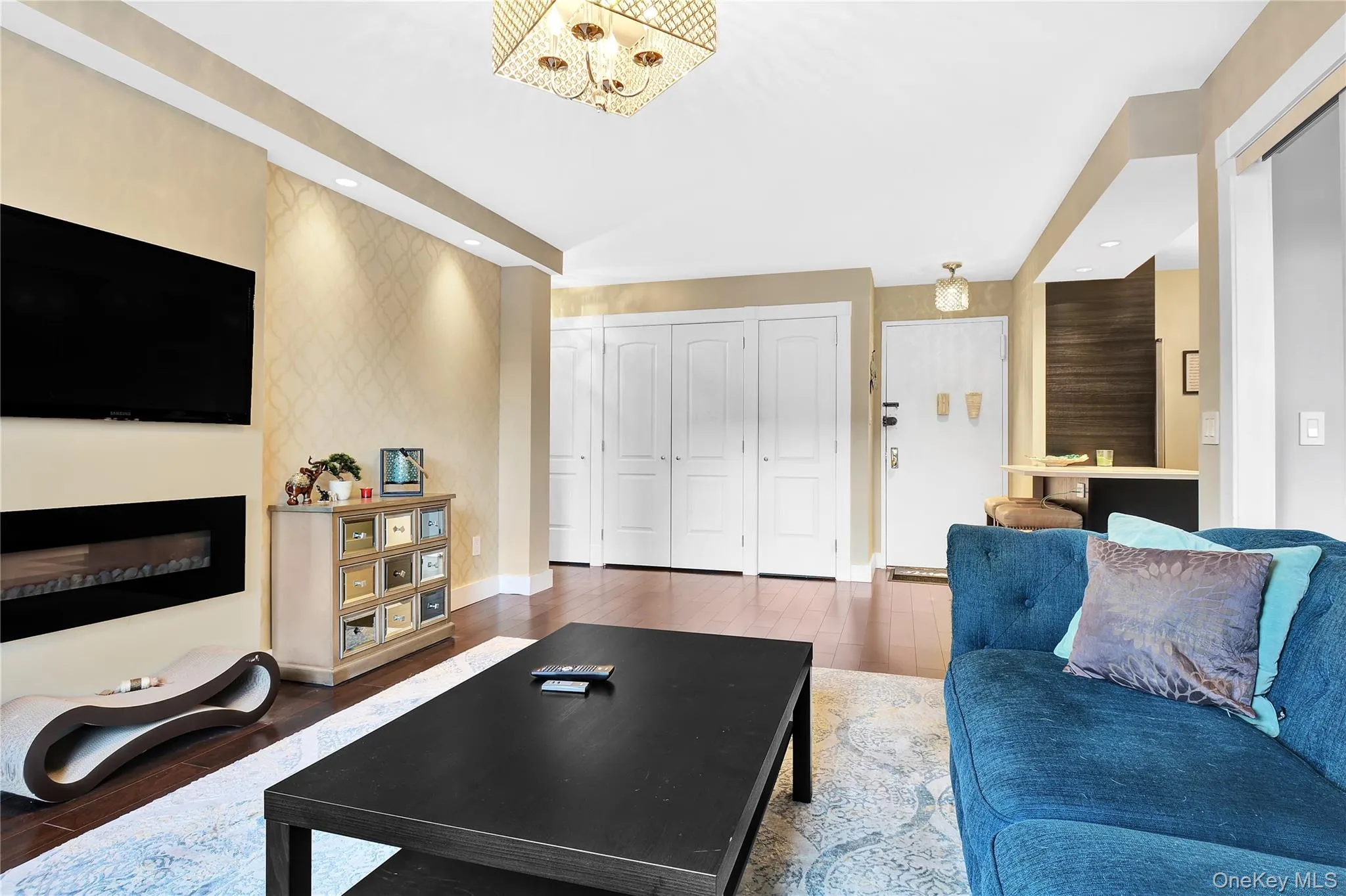 Living area featuring a fireplace, wood finished floors, recessed lighting, and a chandelier Living area featuring a fireplace, wood finished floors, recessed lighting, and a chandelier