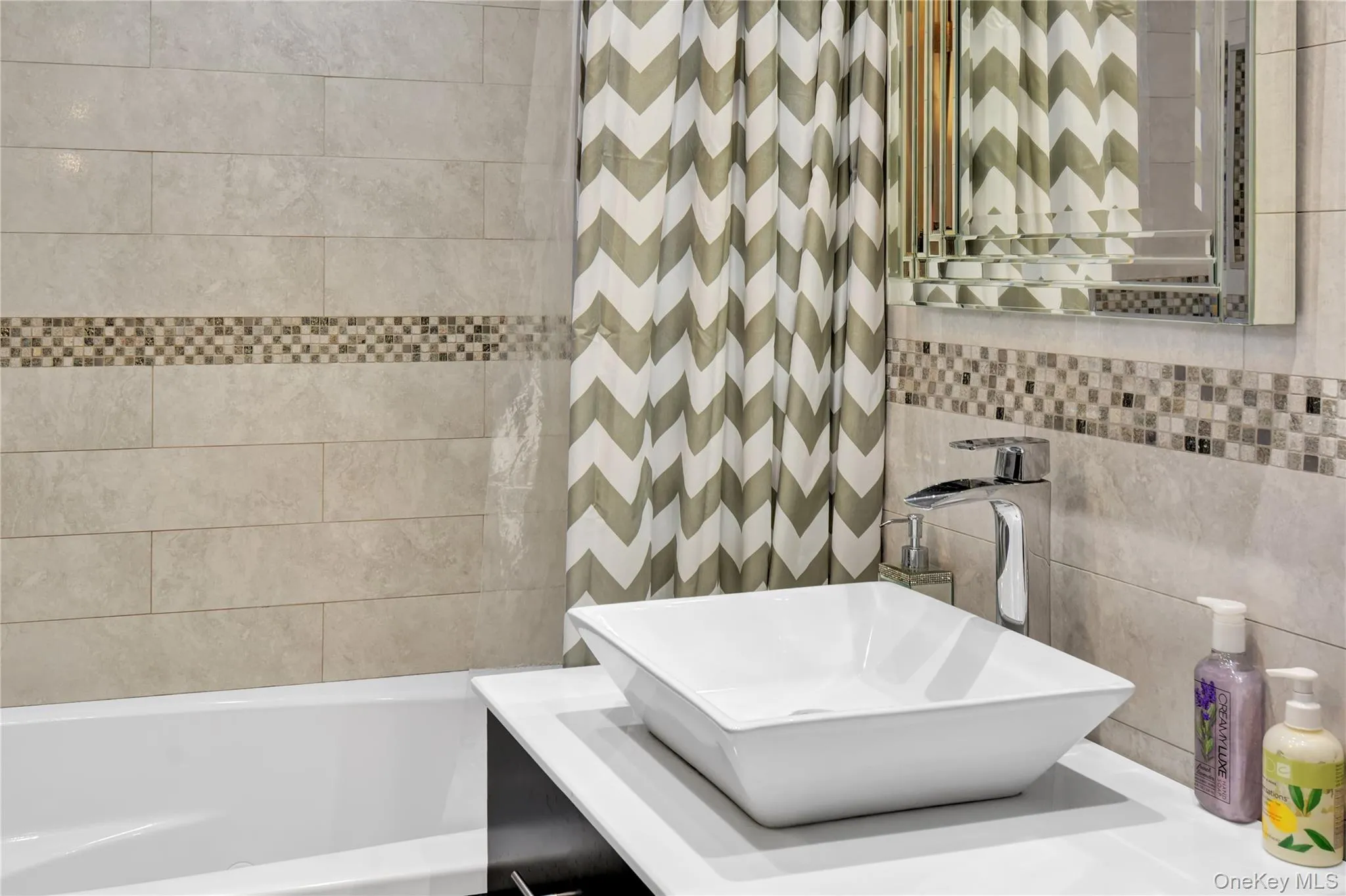 Full bath featuring tile walls and vanity Full bath featuring tile walls and vanity