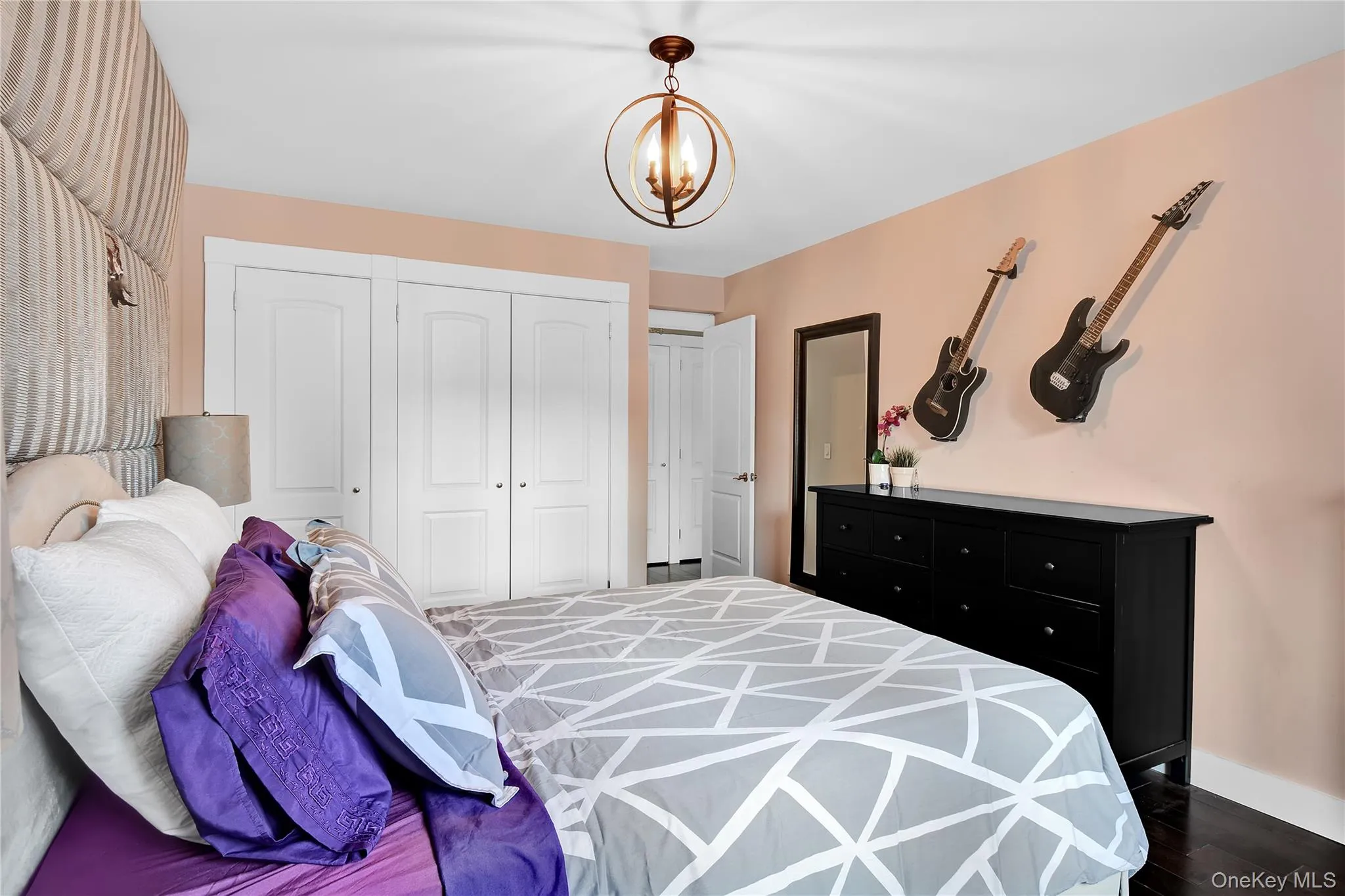 Bedroom with dark wood-style flooring, a closet, and a chandelier Bedroom with dark wood-style flooring, a closet, and a chandelier