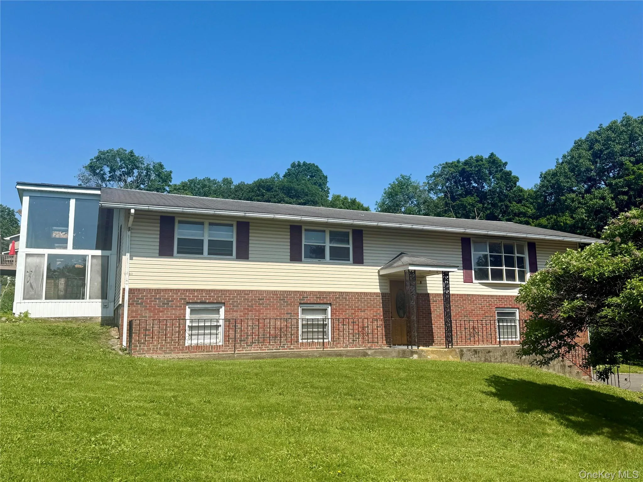 Bi-level home with a front lawn and brick siding Bi-level home with a front lawn and brick siding