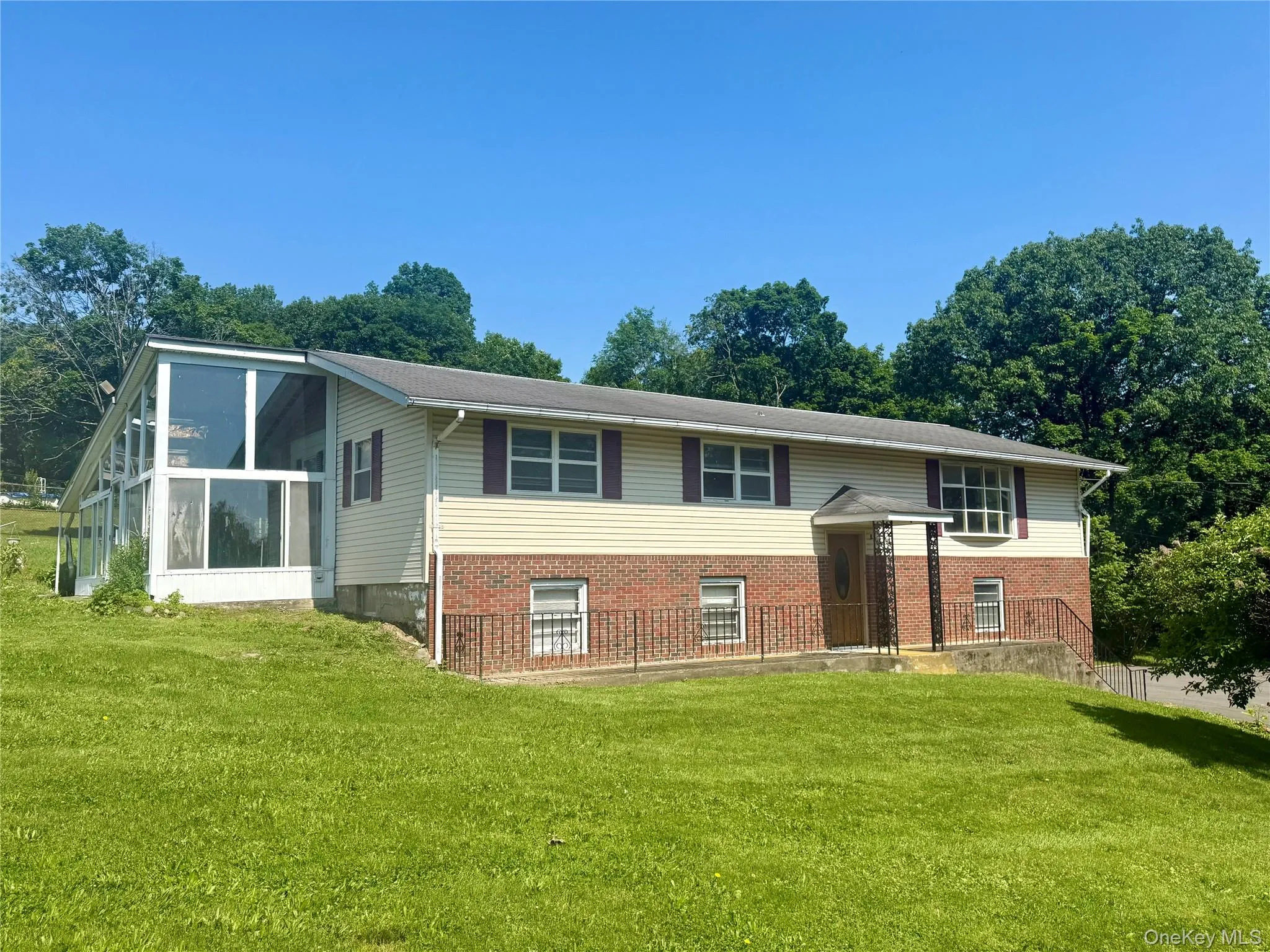 Split foyer home featuring a front yard and brick siding Split foyer home featuring a front yard and brick siding