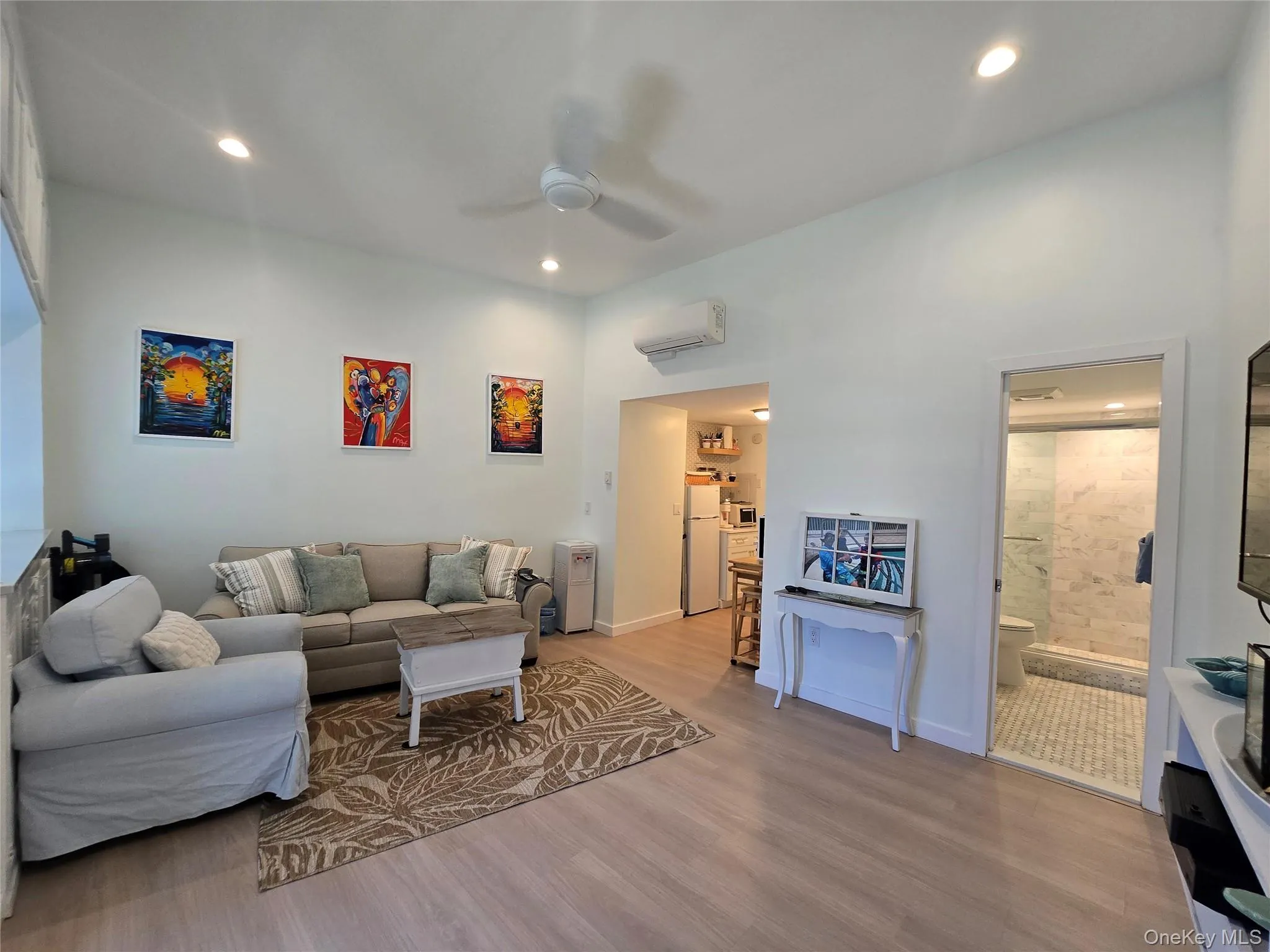 Open living area featuring light wood-finish flooring, recessed lighting, and a ceiling fan Open living area featuring light wood-finish flooring, recessed lighting, and a ceiling fan