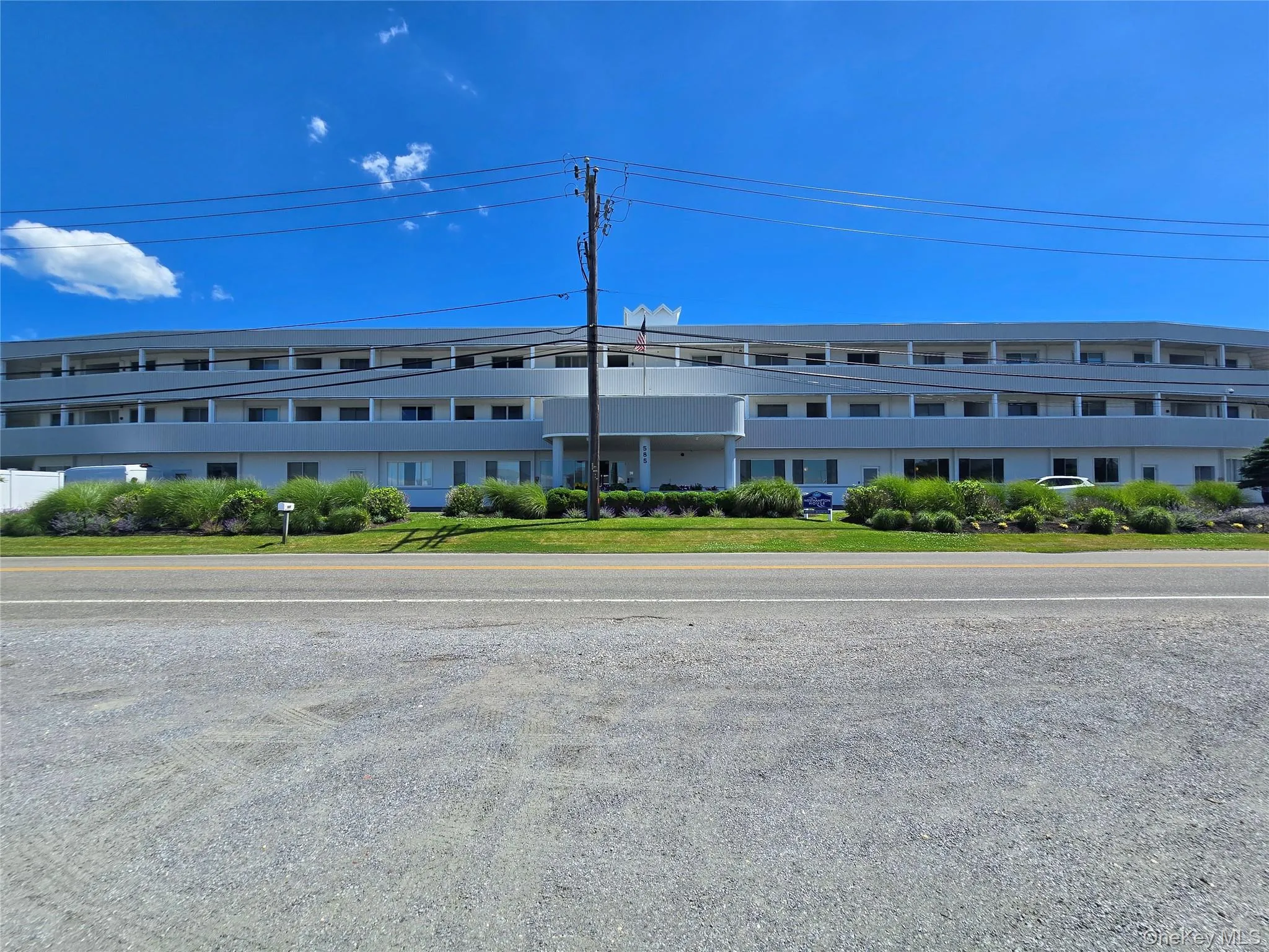 Multi-story structure with a light-colored exterior and multiple balconies Multi-story structure with a light-colored exterior and multiple balconies