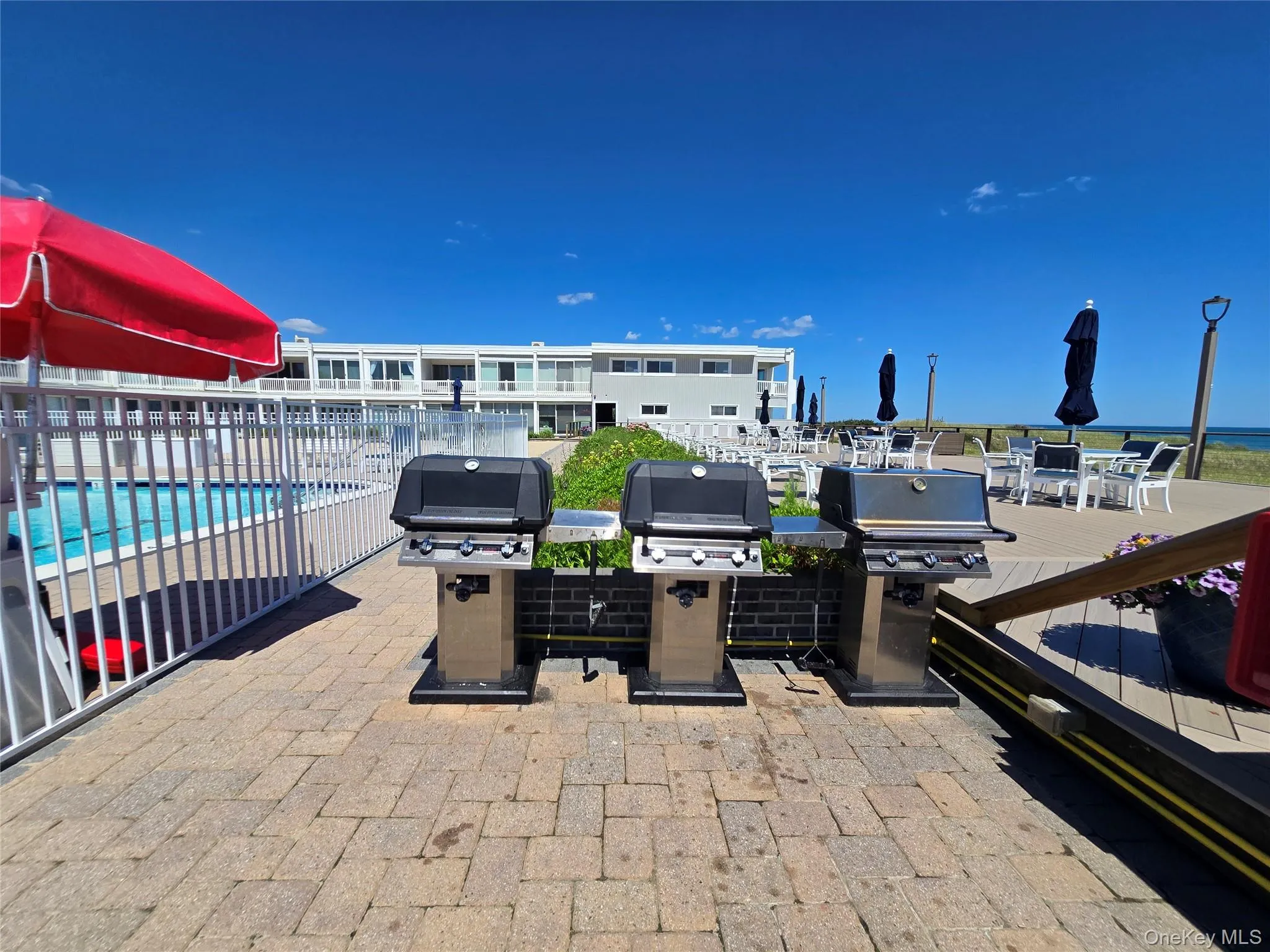 Outdoor grilling station featuring three gas grills on a paver patio Outdoor grilling station featuring three gas grills on a paver patio
