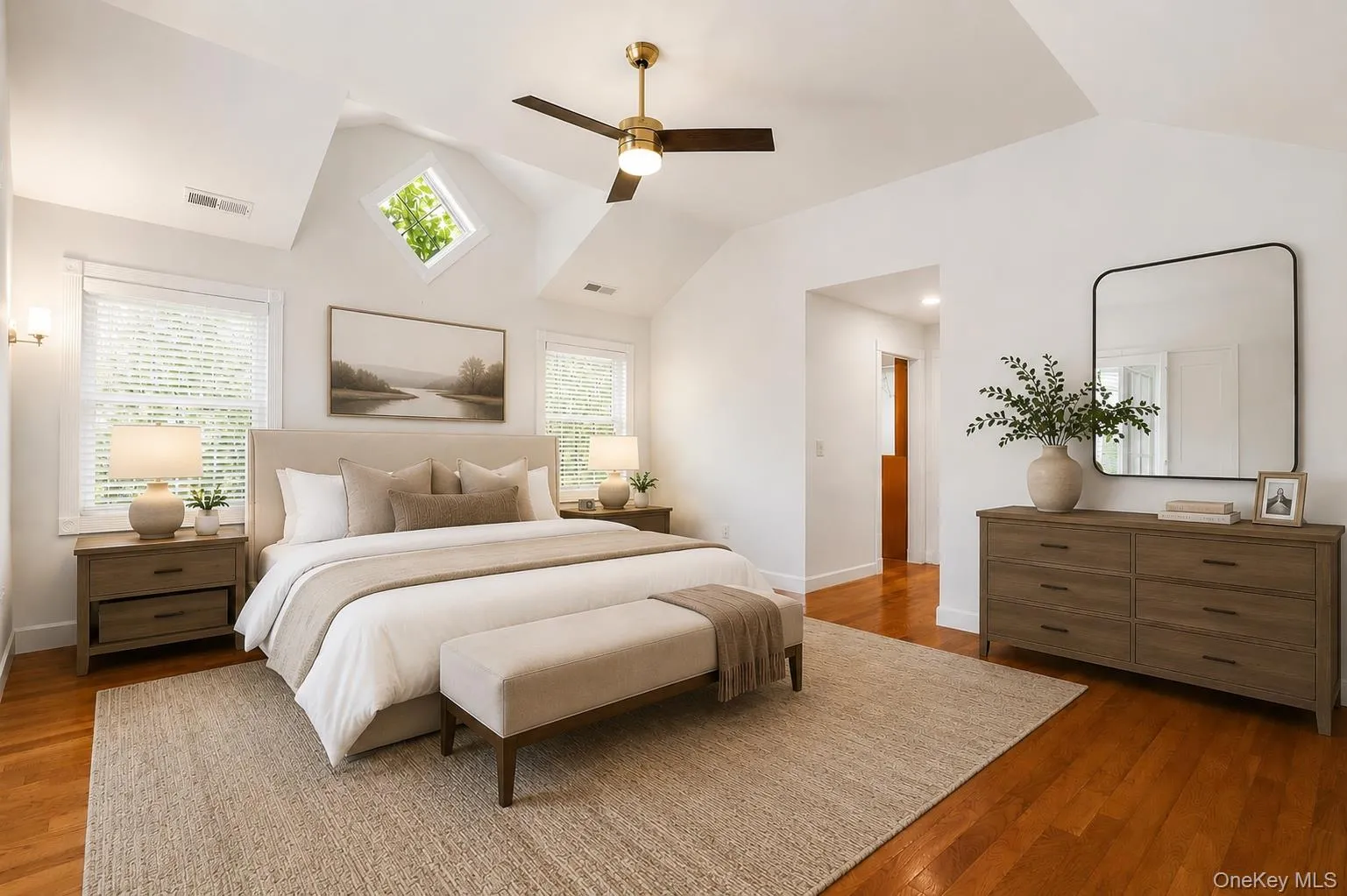 Spacious bedroom featuring vaulted ceilings, wood-finish flooring, and multiple windows including a prominent diamond-shaped window Spacious bedroom featuring vaulted ceilings, wood-finish flooring, and multiple windows including a prominent diamond-shaped window