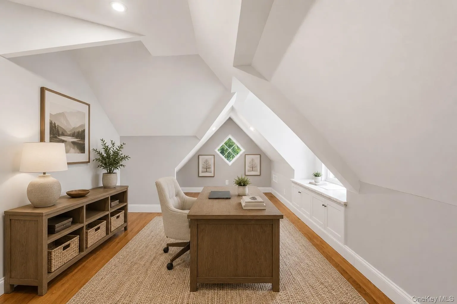 Attic space featuring pitched ceilings, wood-finish flooring, built-in recessed lighting, and a built-in window seat with cabinetry Attic space featuring pitched ceilings, wood-finish flooring, built-in recessed lighting, and a built-in window seat with cabinetry