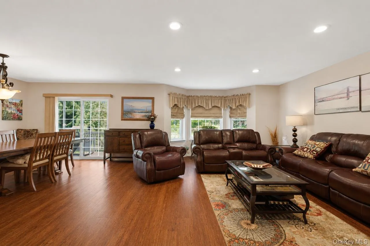 Expansive living area featuring warm wood-finish flooring throughout Expansive living area featuring warm wood-finish flooring throughout