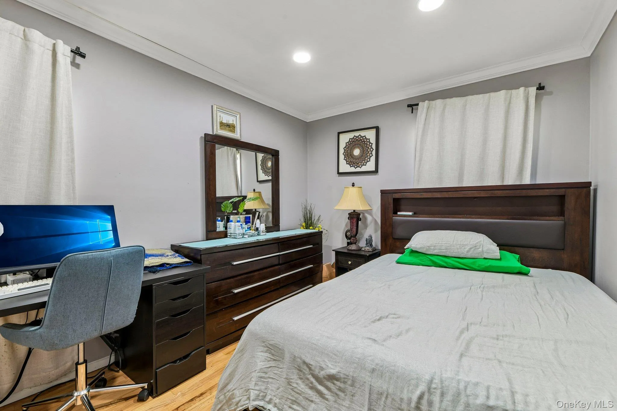 Bedroom featuring light wood-finish flooring and grey wall paint Bedroom featuring light wood-finish flooring and grey wall paint