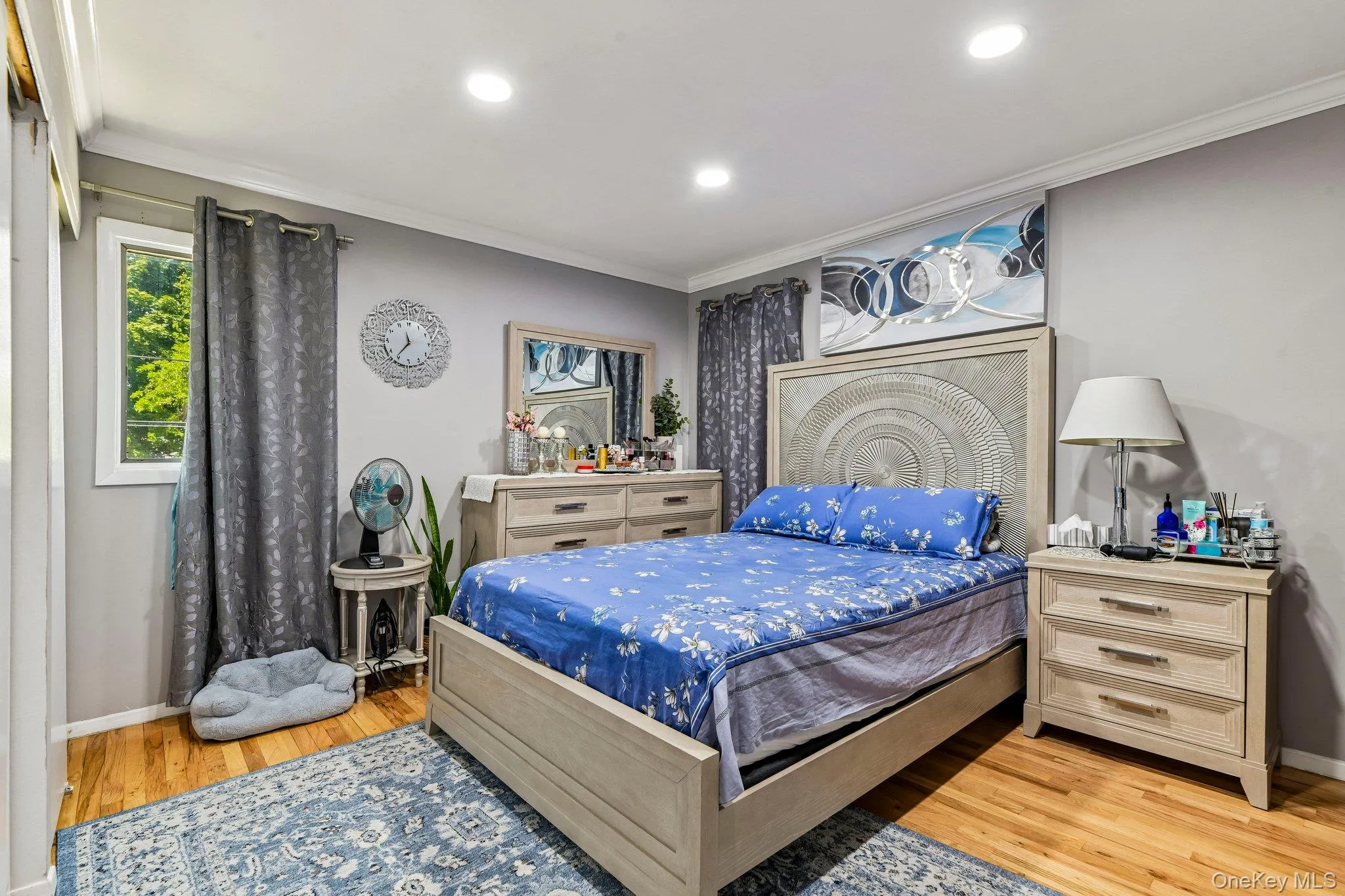 Bedroom featuring hardwood flooring, recessed lighting, crown molding, and a window with exterior tree views Bedroom featuring hardwood flooring, recessed lighting, crown molding, and a window with exterior tree views