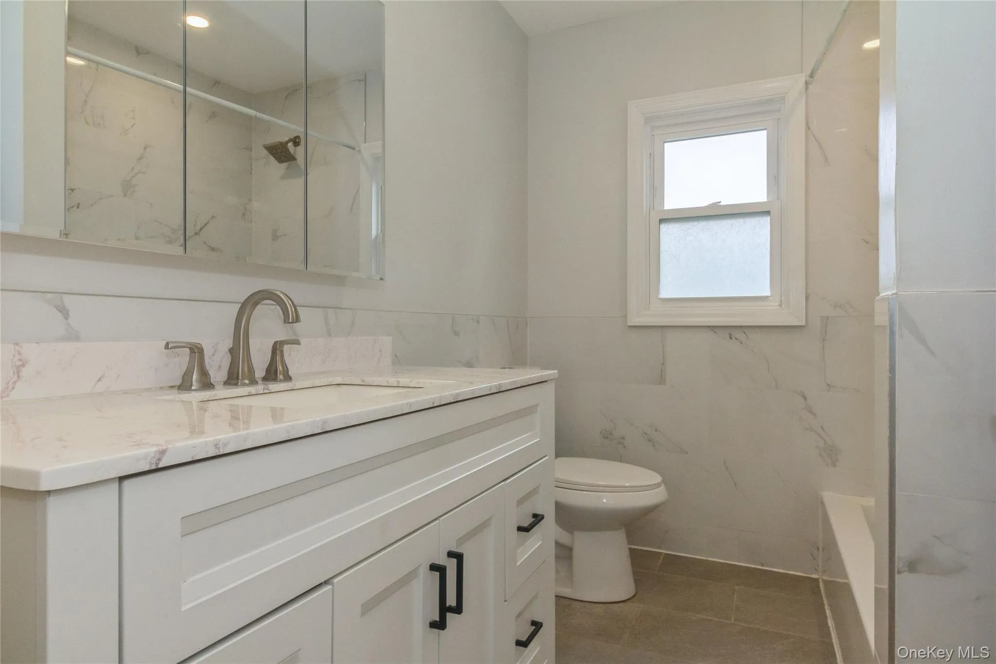 Bathroom featuring a white vanity with an integrated sink, brushed nickel faucet, and a wall-mounted mirrored medicine cabinet Bathroom featuring a white vanity with an integrated sink, brushed nickel faucet, and a wall-mounted mirrored medicine cabinet