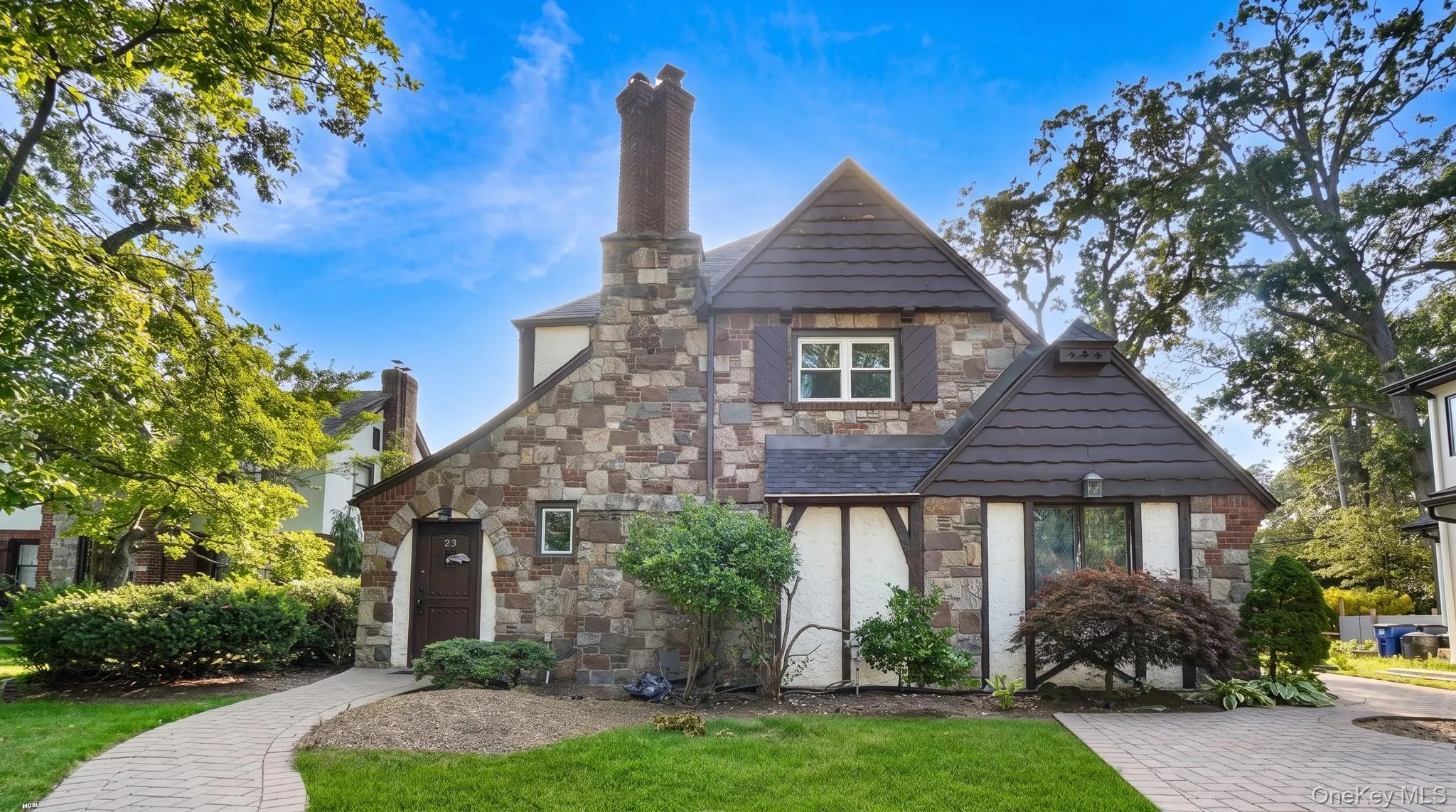 Stone and stucco exterior with a prominent brick chimney, gabled rooflines, and decorative shutters Stone and stucco exterior with a prominent brick chimney, gabled rooflines, and decorative shutters