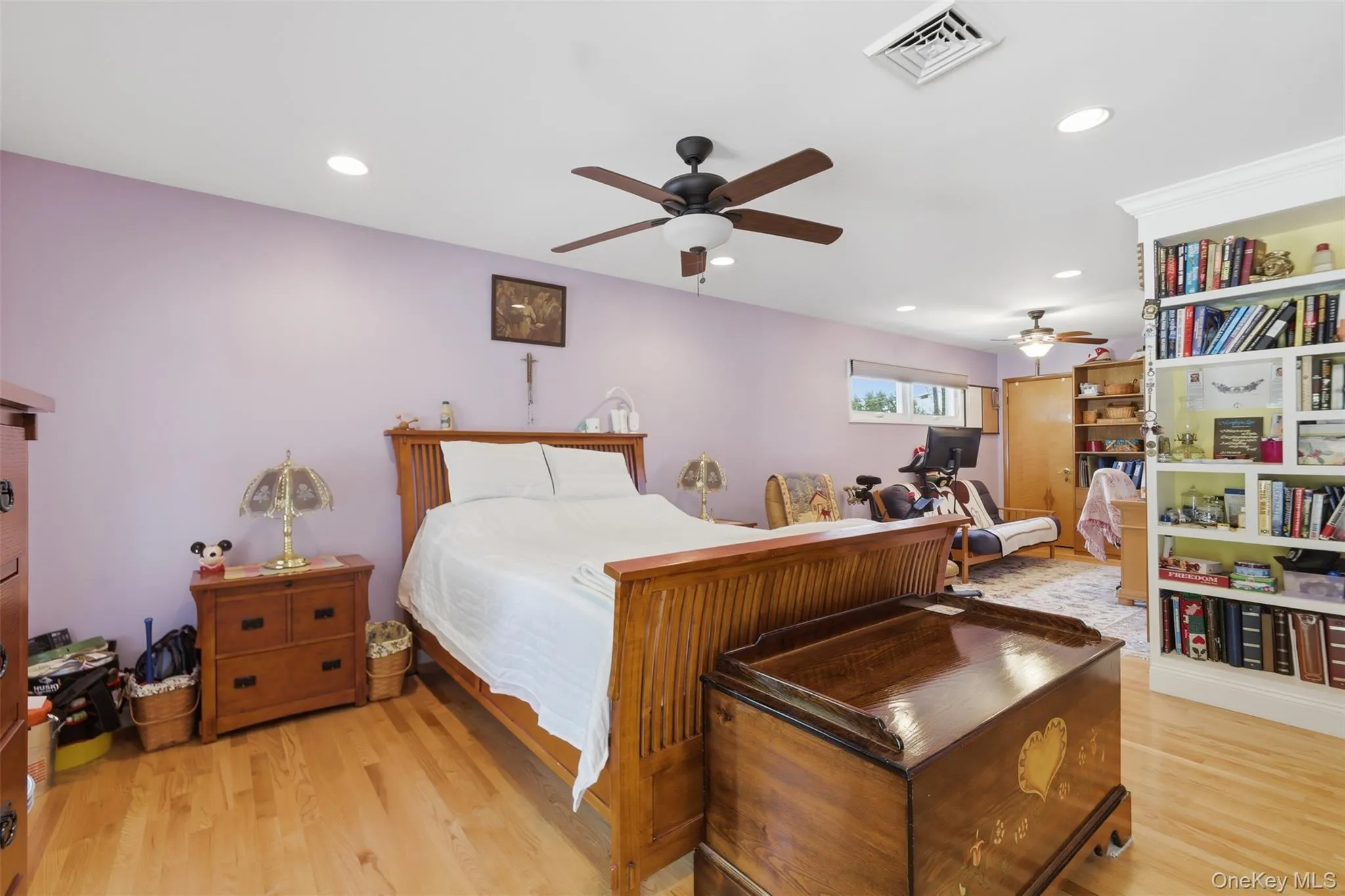 Spacious room featuring wood-finish flooring, recessed lighting, and a ceiling fan Spacious room featuring wood-finish flooring, recessed lighting, and a ceiling fan