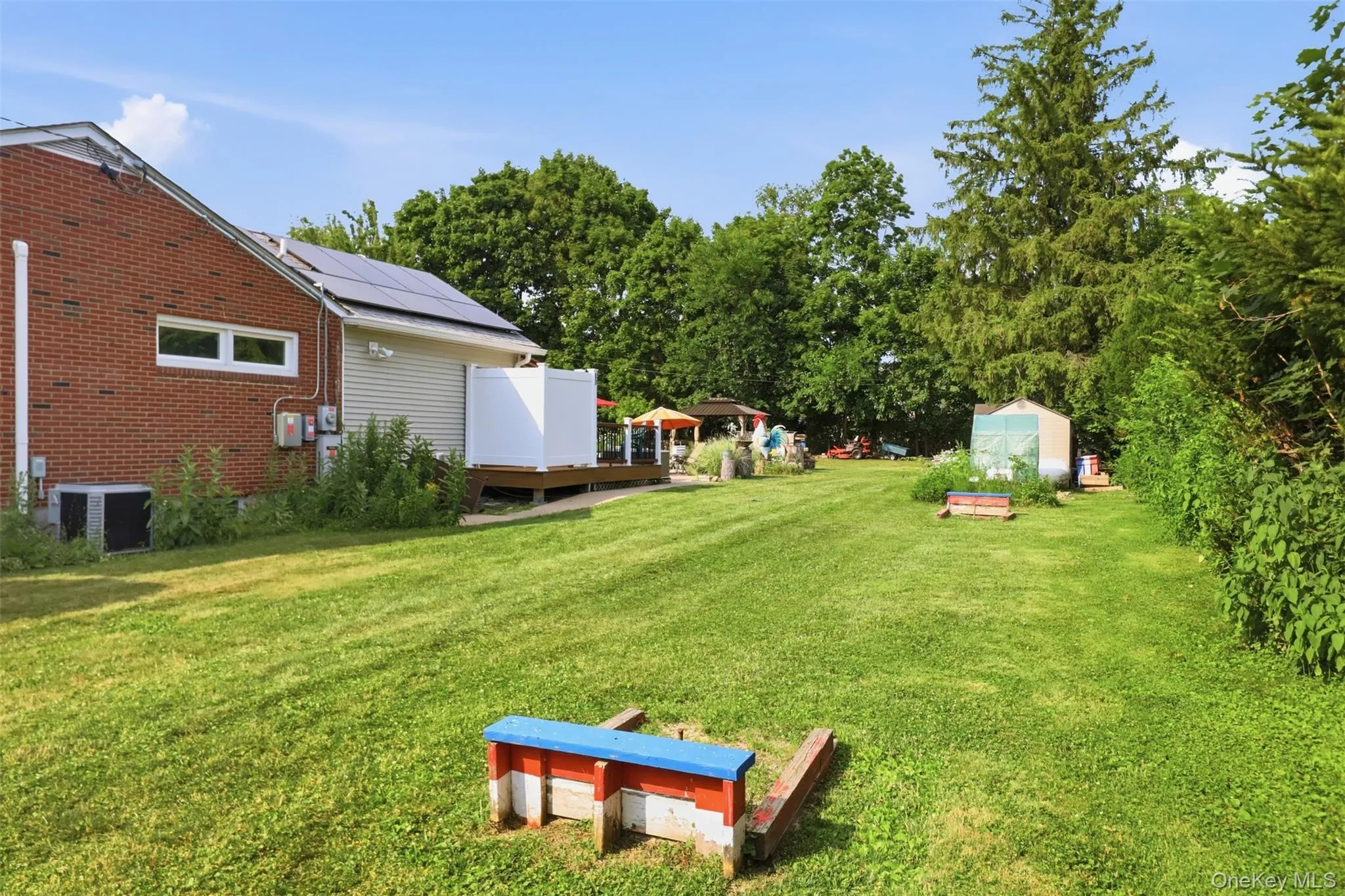 Expansive green lawn with a red brick exterior and tan siding Expansive green lawn with a red brick exterior and tan siding