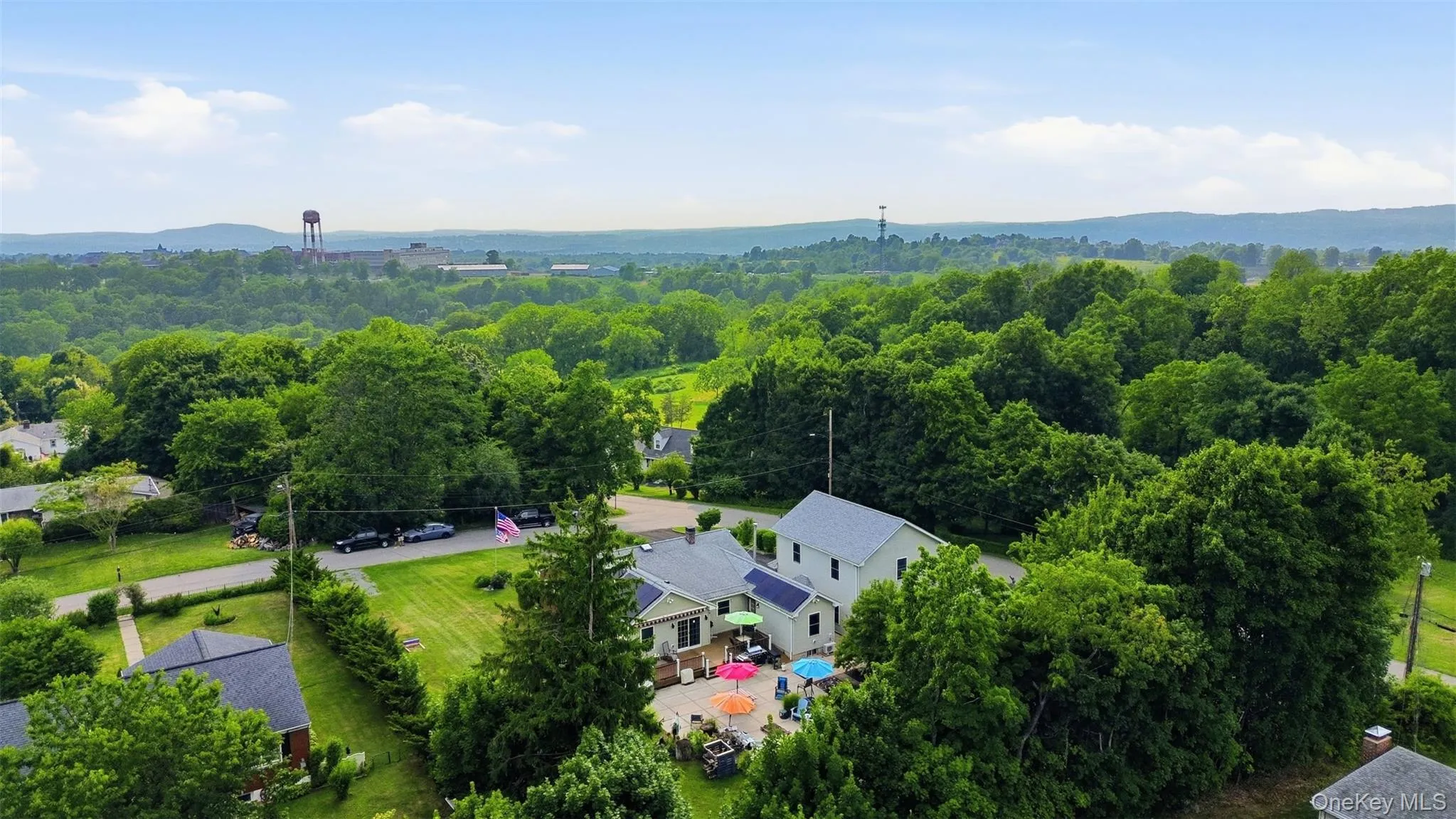 Expansive property featuring a large patio, mature trees, and solar panels Expansive property featuring a large patio, mature trees, and solar panels