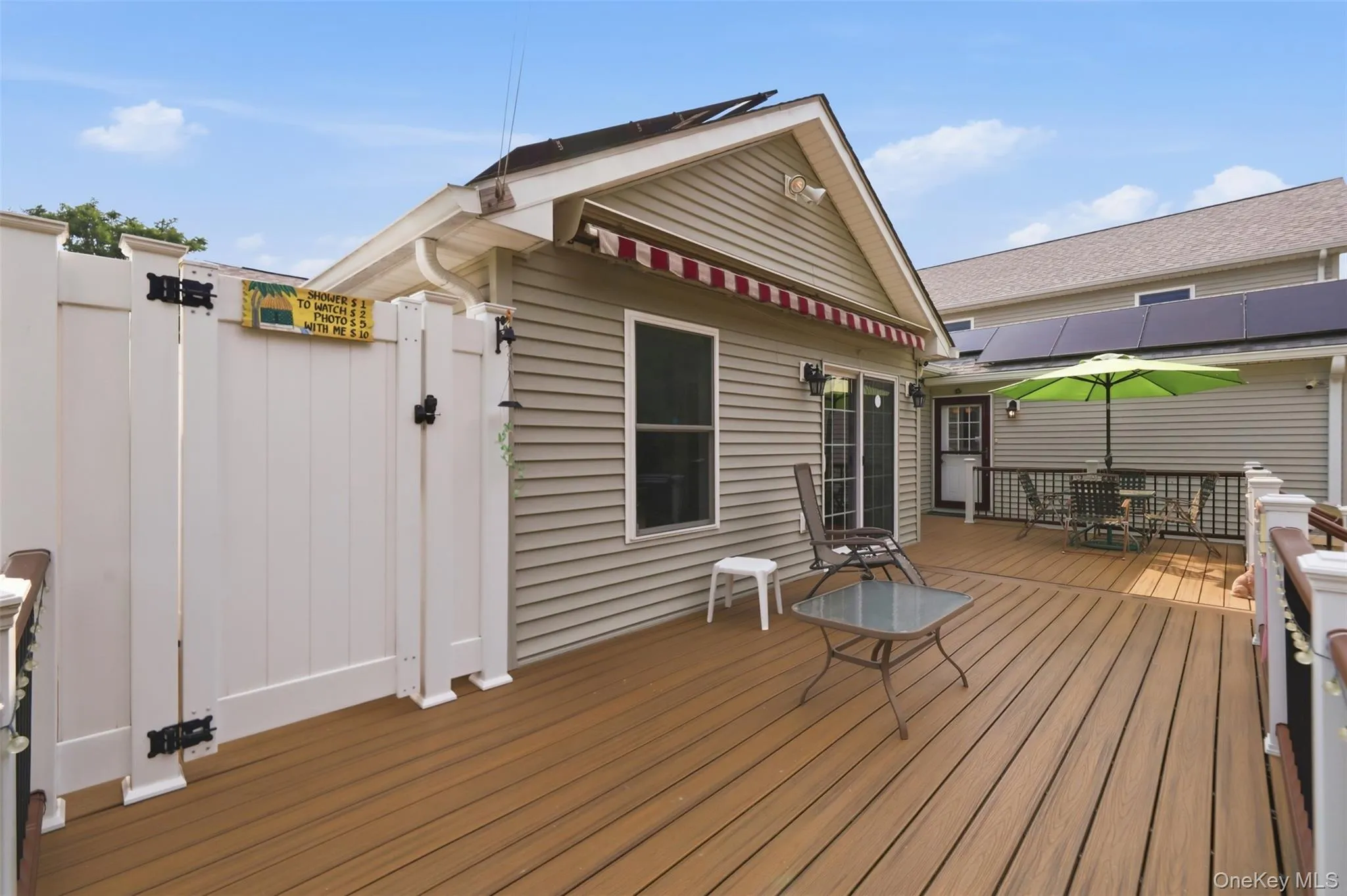 Wood-finish composite decking with white railings and outdoor shower Wood-finish composite decking with white railings and outdoor shower