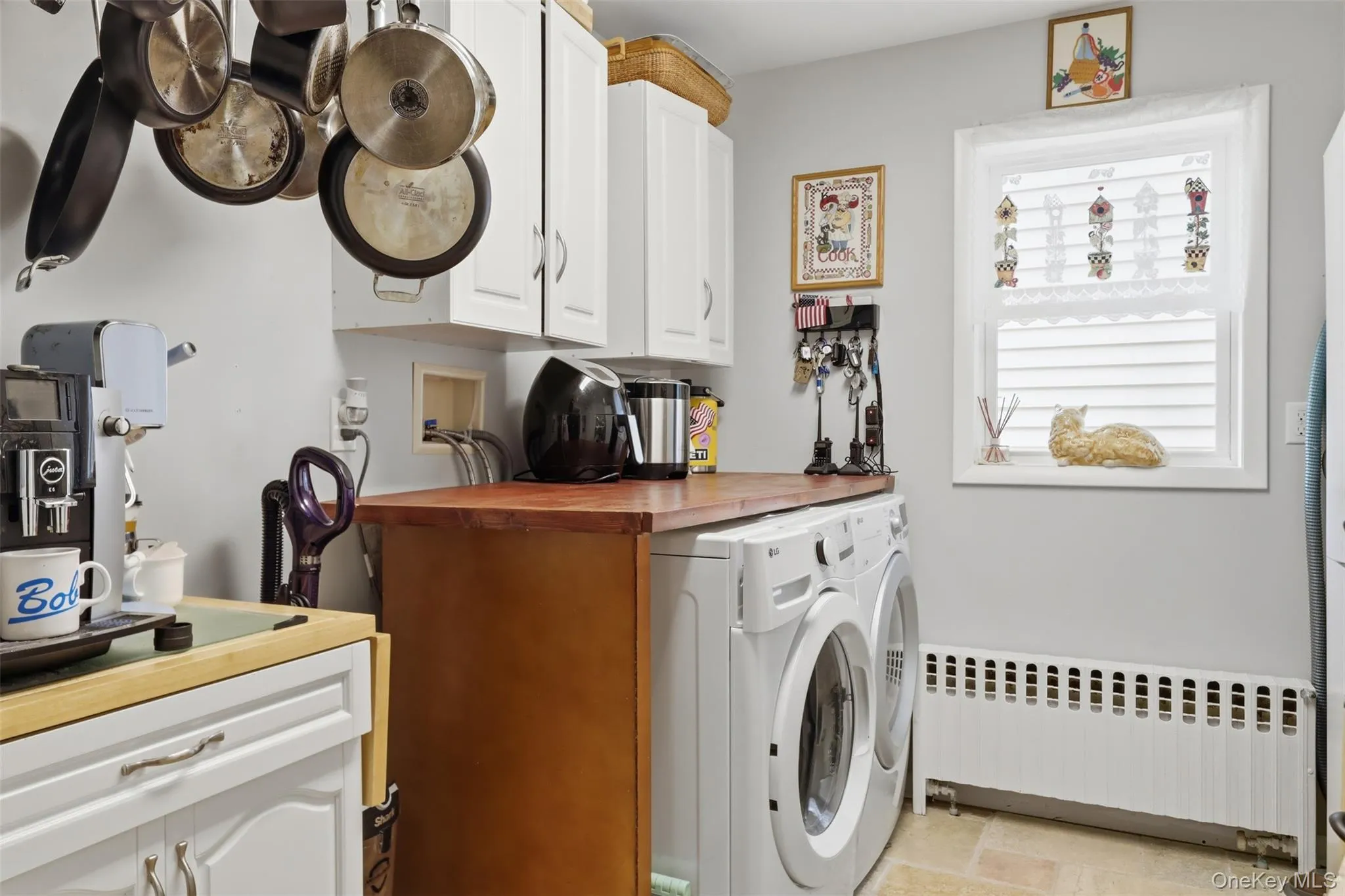 Functional laundry area with front-loading washer and dryer units, complemented by a wood-finish countertop Functional laundry area with front-loading washer and dryer units, complemented by a wood-finish countertop