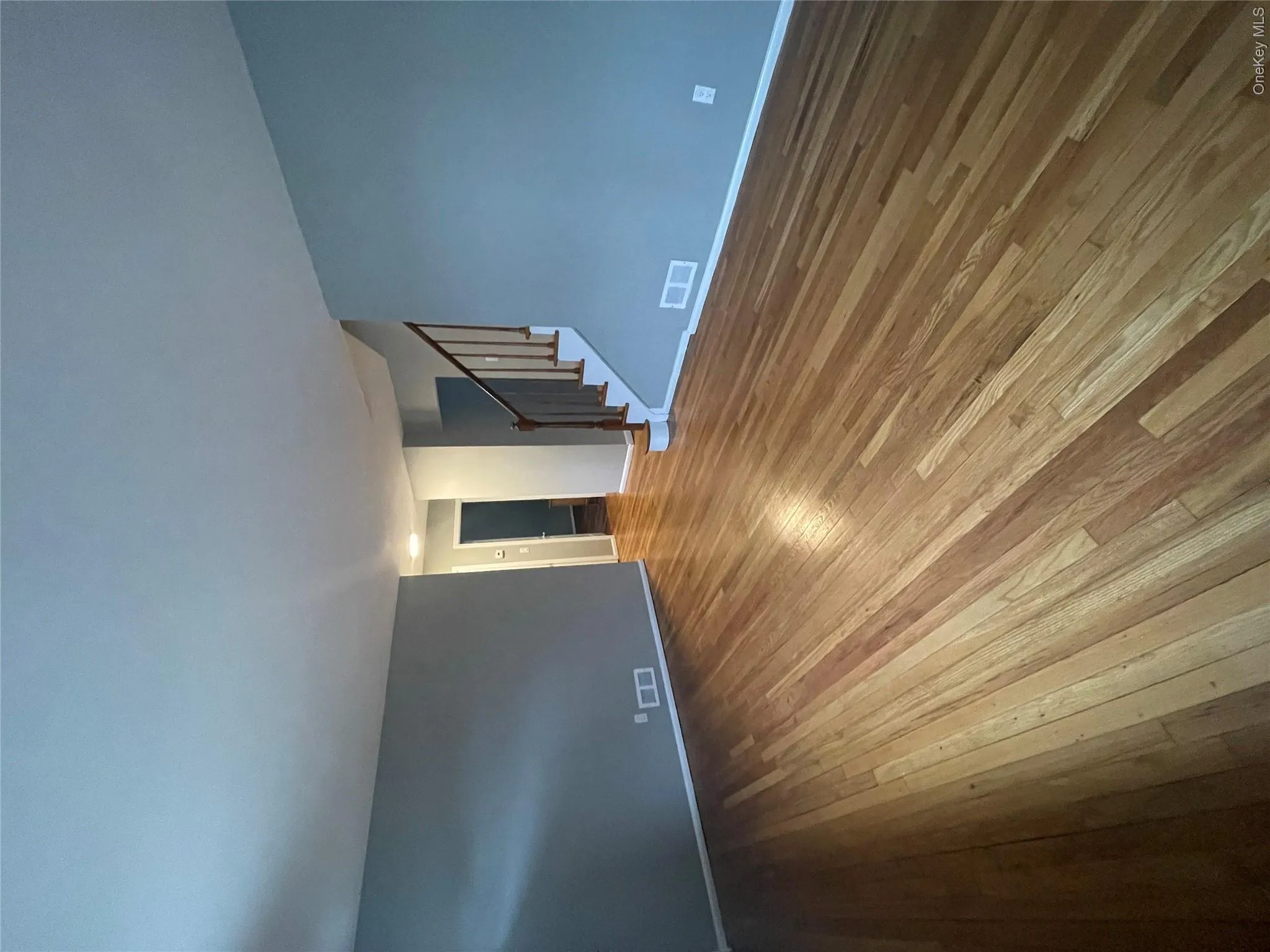 Unfurnished living room with wood-type flooring, stairs Unfurnished living room with wood-type flooring, stairs