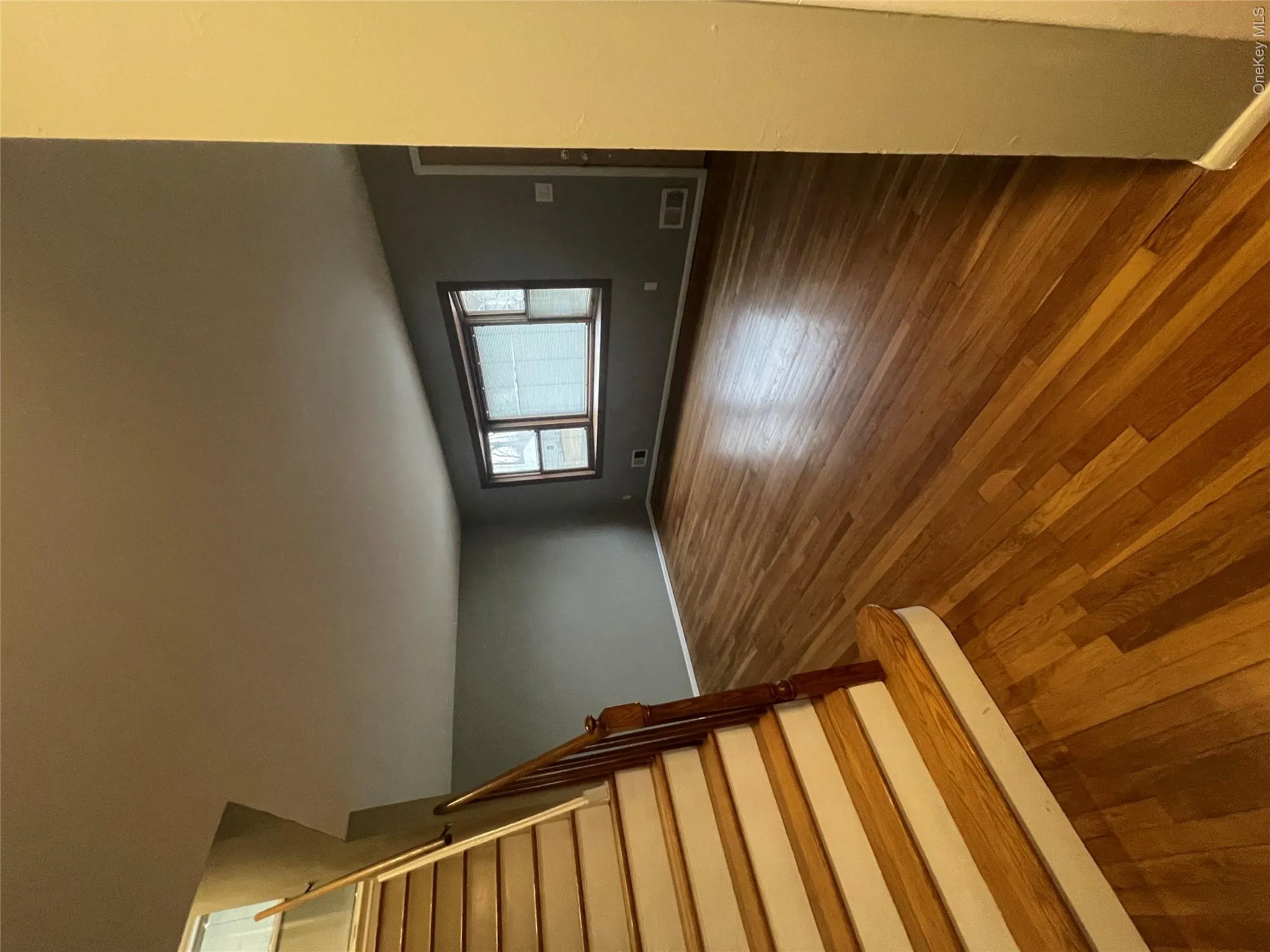 Unfurnished living room featuring dark wood-type flooring, visible vents, stairway, and baseboards Unfurnished living room featuring dark wood-type flooring, visible vents, stairway, and baseboards