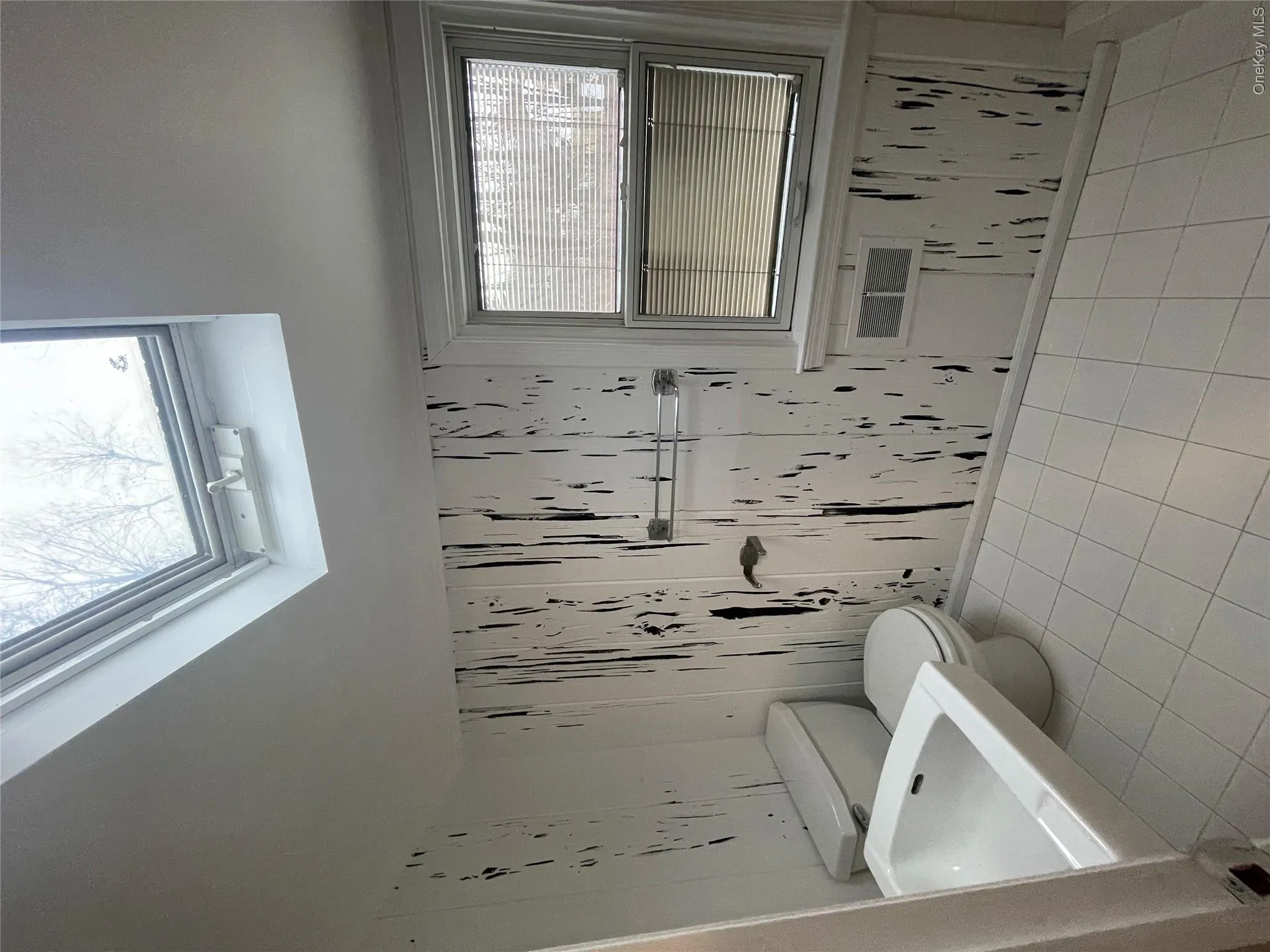 Bathroom featuring a skylight, tile patterned flooring, and toilet Bathroom featuring a skylight, tile patterned flooring, and toilet
