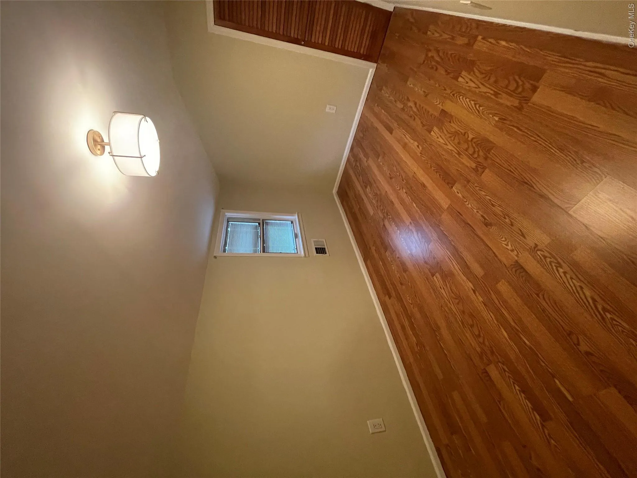 Unfurnished room with visible vents, baseboards, and wood finished floors Unfurnished room with visible vents, baseboards, and wood finished floors