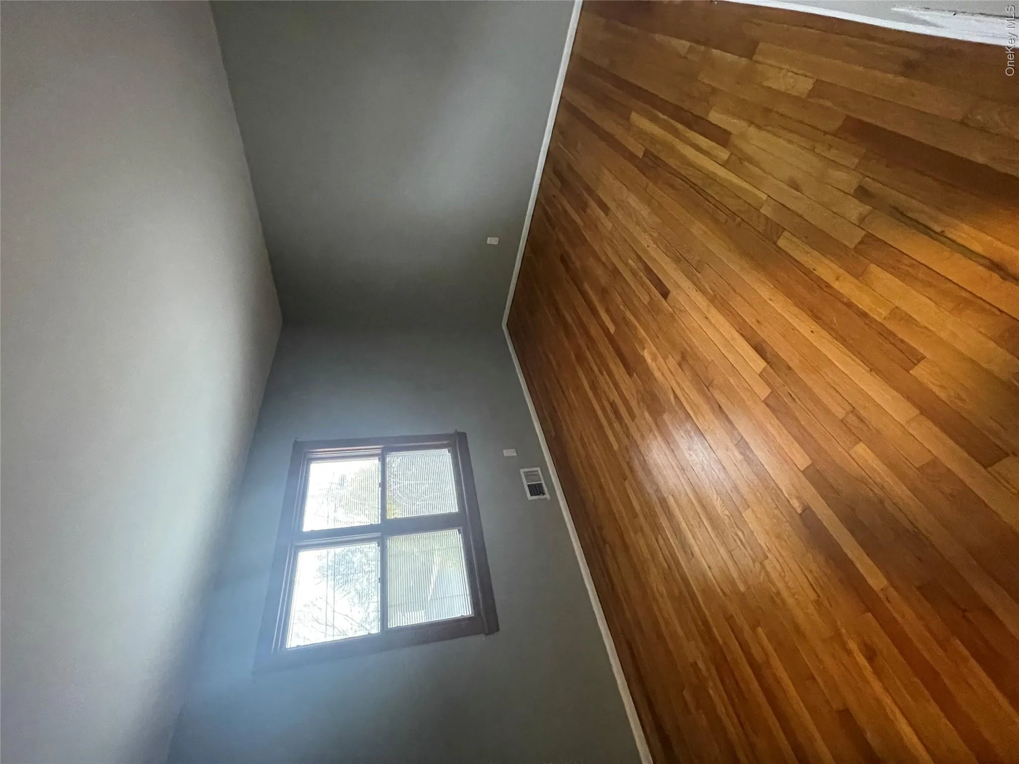 Spare room featuring baseboards, visible vents, and dark wood-type flooring Spare room featuring baseboards, visible vents, and dark wood-type flooring