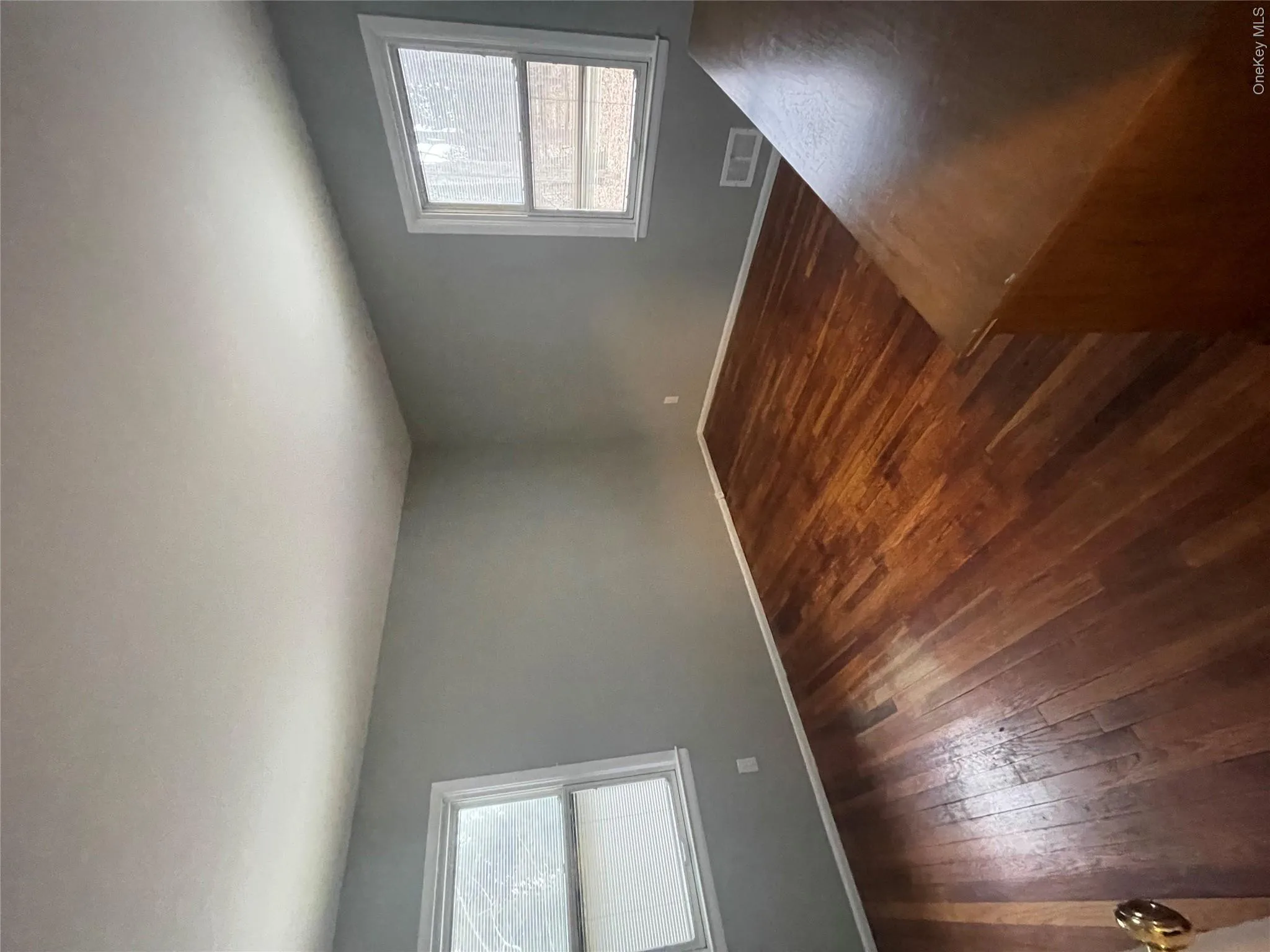 Unfurnished room with dark wood-style flooring, visible vents, and baseboards Unfurnished room with dark wood-style flooring, visible vents, and baseboards
