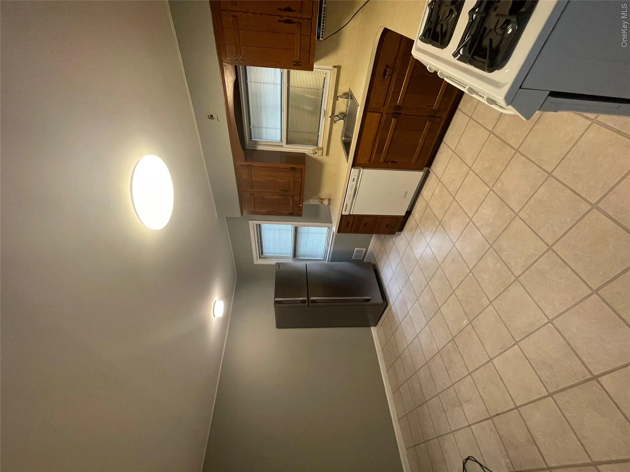 Kitchen featuring dishwashing machine, stove, light countertops, and refrigerator Kitchen featuring dishwashing machine, stove, light countertops, and refrigerator