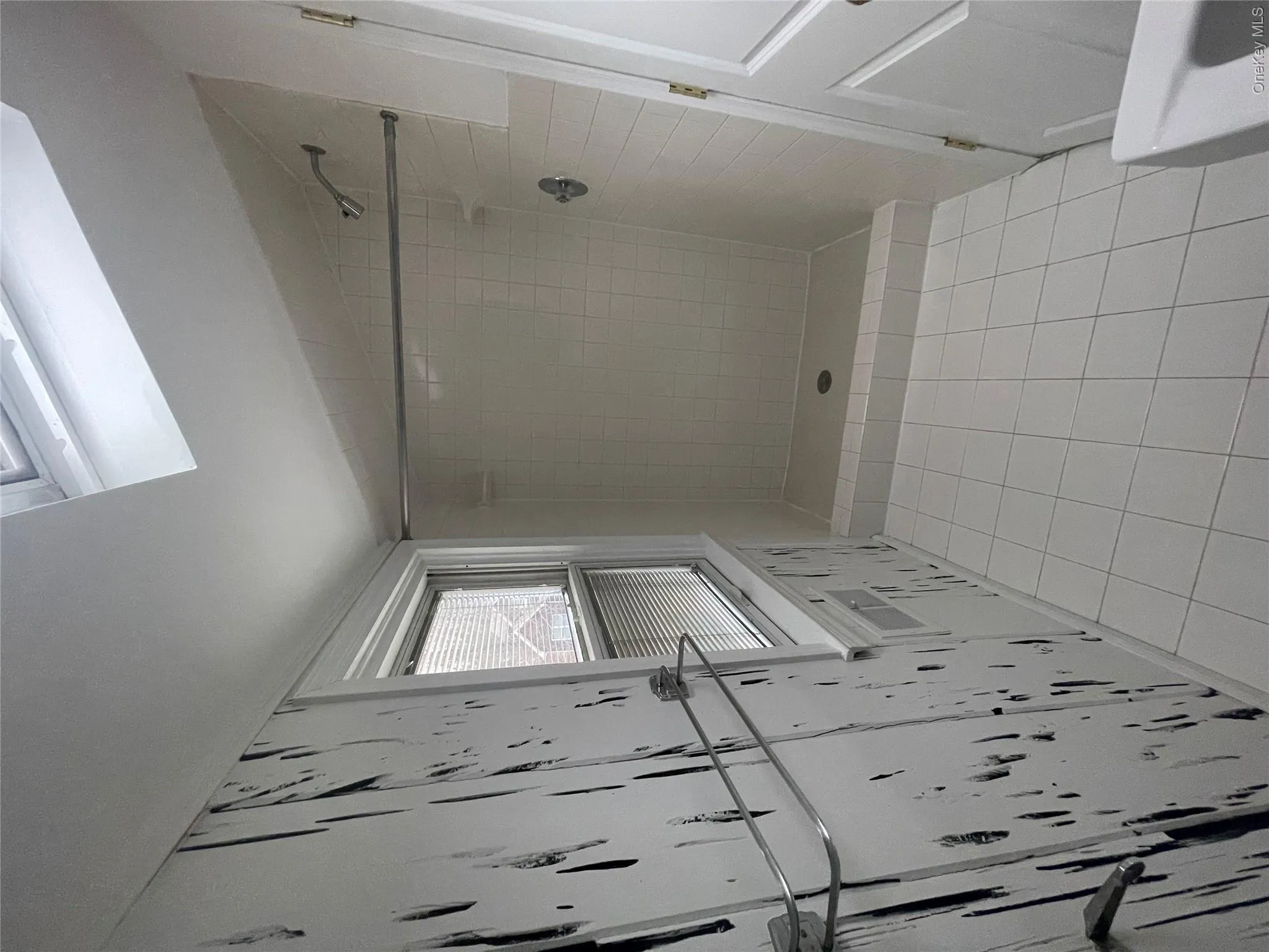 Bathroom featuring lofted ceiling, tiled shower, and tile patterned floors Bathroom featuring lofted ceiling, tiled shower, and tile patterned floors