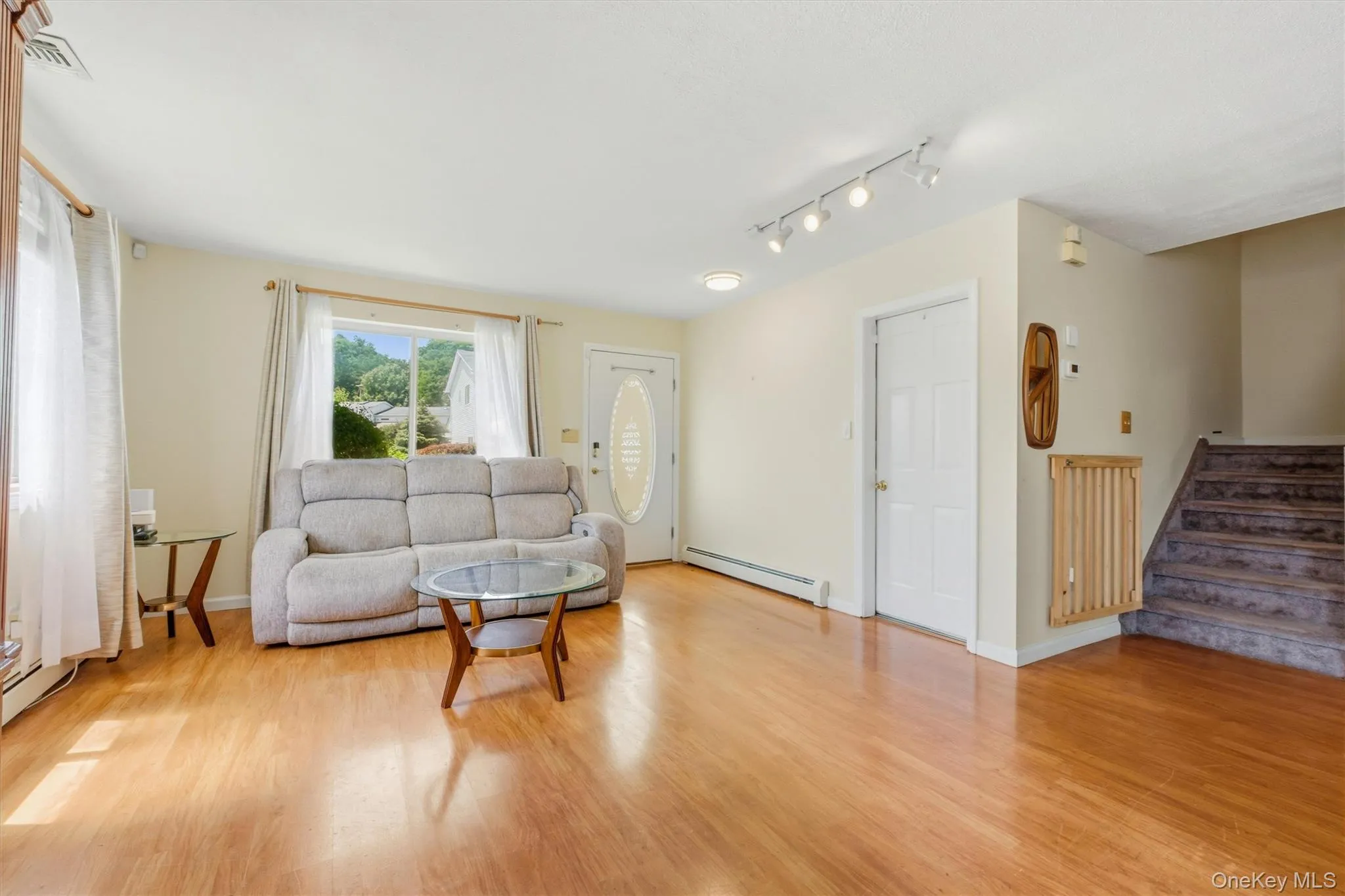 Warm wood-finish flooring throughout this open living area Warm wood-finish flooring throughout this open living area