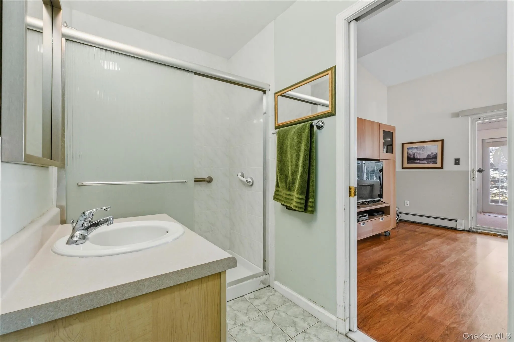 Bathroom featuring a single vanity with an integrated sink, chrome faucet, and mirrored medicine cabinet Bathroom featuring a single vanity with an integrated sink, chrome faucet, and mirrored medicine cabinet
