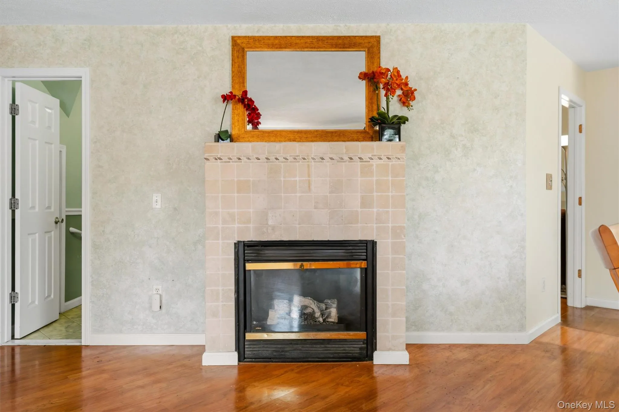 Fireplace with a tiled surround and mantel, creating a warm focal point in the main living area. Fireplace with a tiled surround and mantel, creating a warm focal point in the main living area.